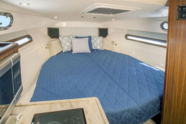 Manufacturer Provided Image: Interior cabin of 2021 Pursuit OS 325 Offshore with blue bedding and modern amenities.