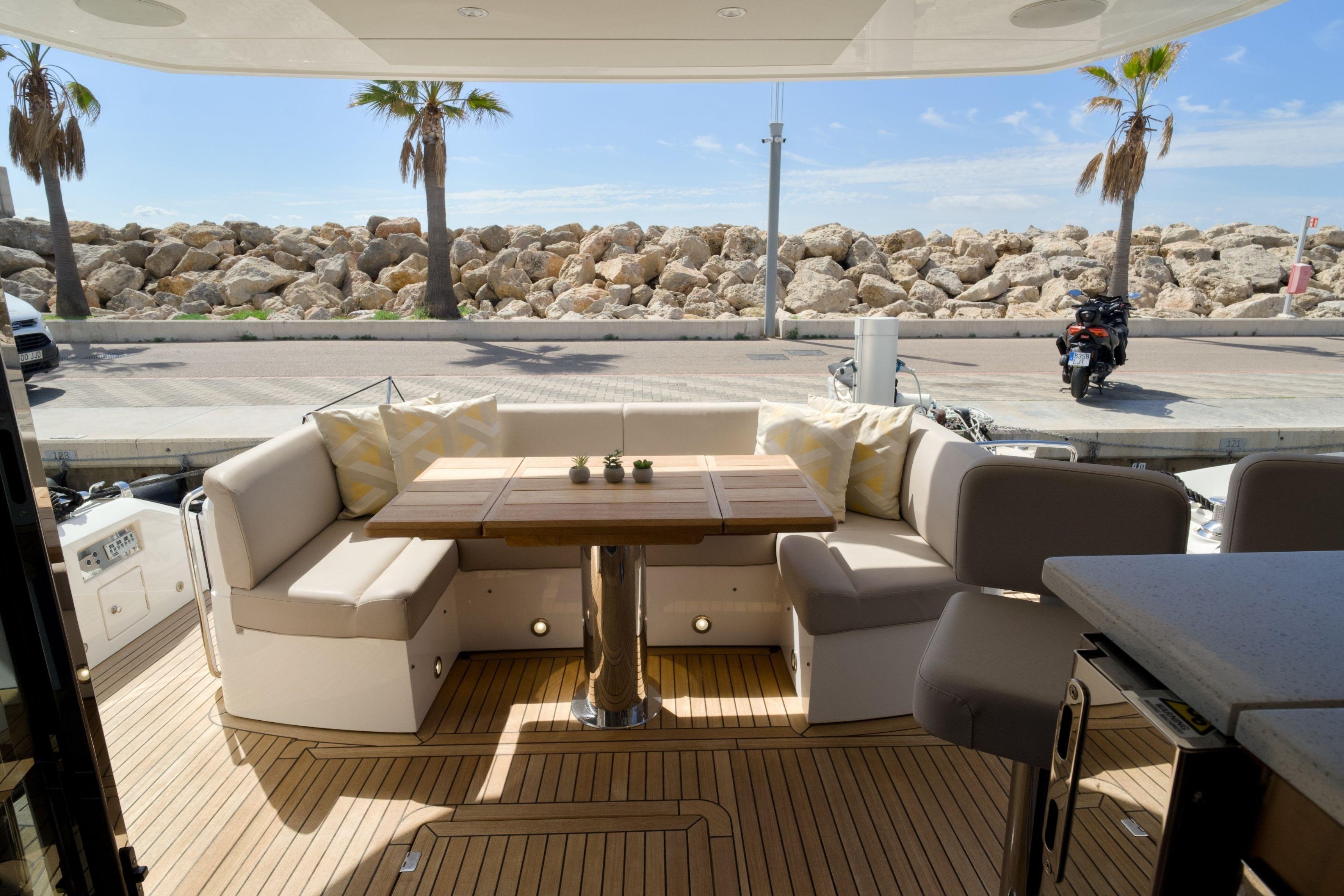 Luxurious 2019 Sunseeker Manhattan 52 yacht deck with elegant seating and scenic marina view.
