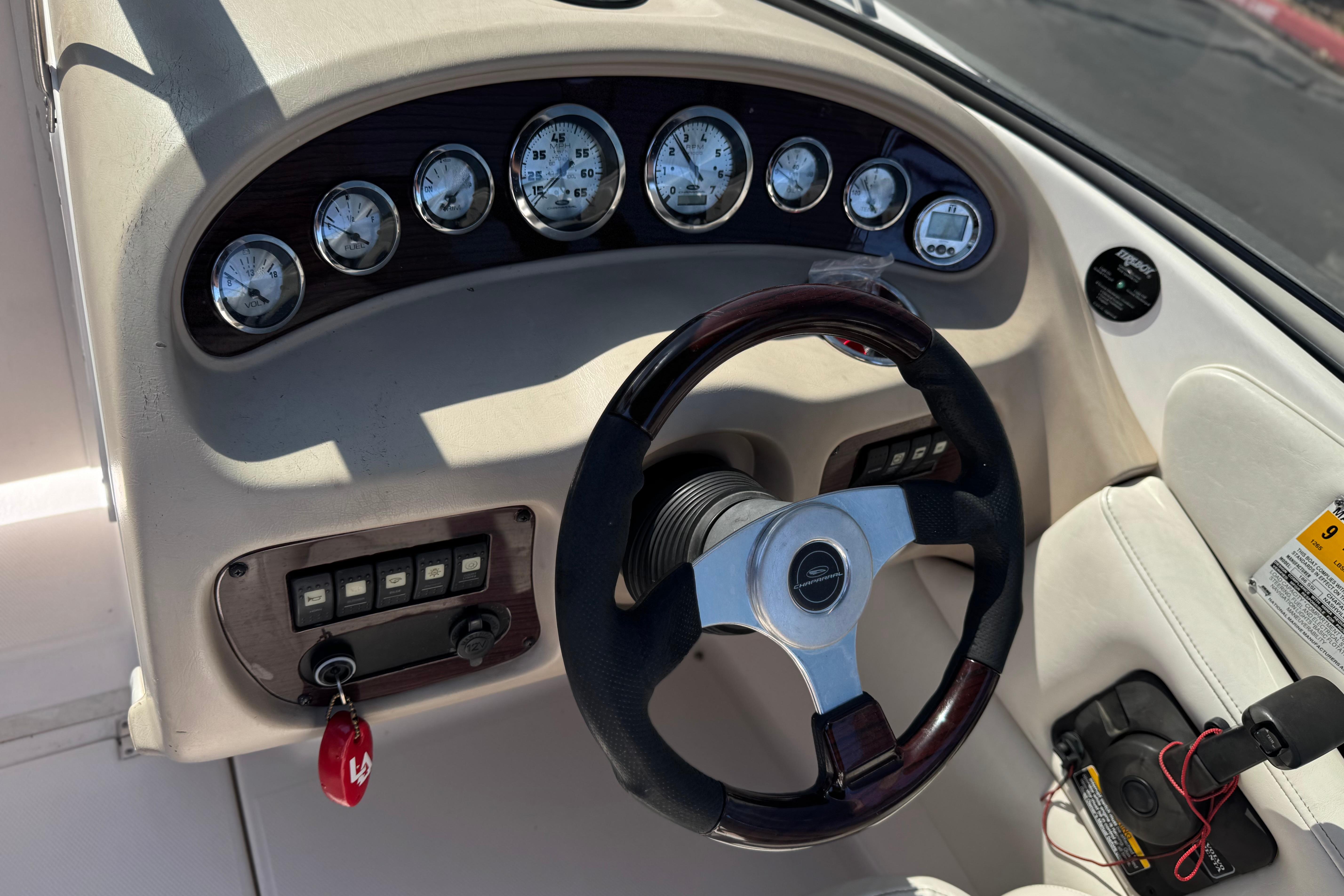 Steering wheel and dashboard of a 2002 Chaparral 186 SSi boat, featuring gauges and controls.