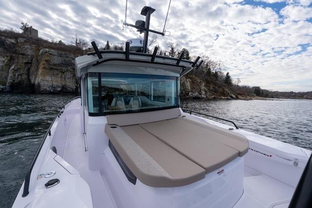 2026 Axopar 37 XC Cross Cabin boat on scenic water with rocky shoreline.