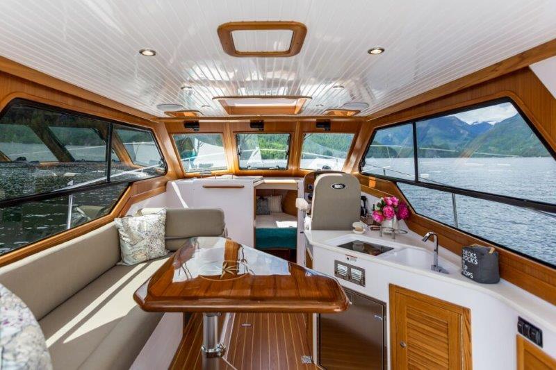 Luxurious 2024 True North 34 yacht interior with panoramic windows and elegant wood finishes.