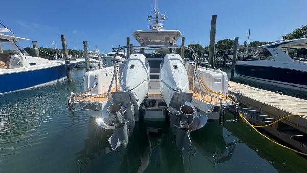 Sleek 2025 Nimbus T11 boat docked, showcasing dual outboard engines in a marina setting.