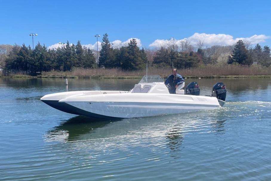2025 Hustler 25 C3 Speedfish boat cruising on a calm lake.