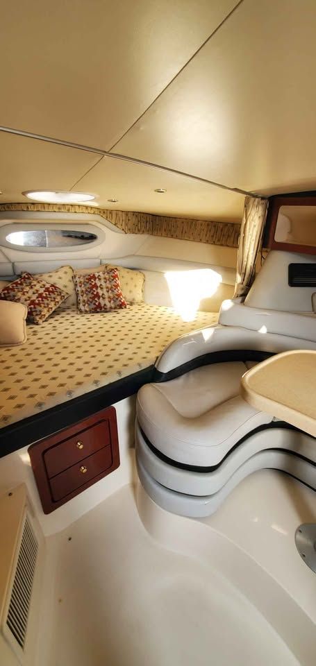 Interior of a 2002 Wellcraft 3300 Martinique with a cozy bed and seating area.