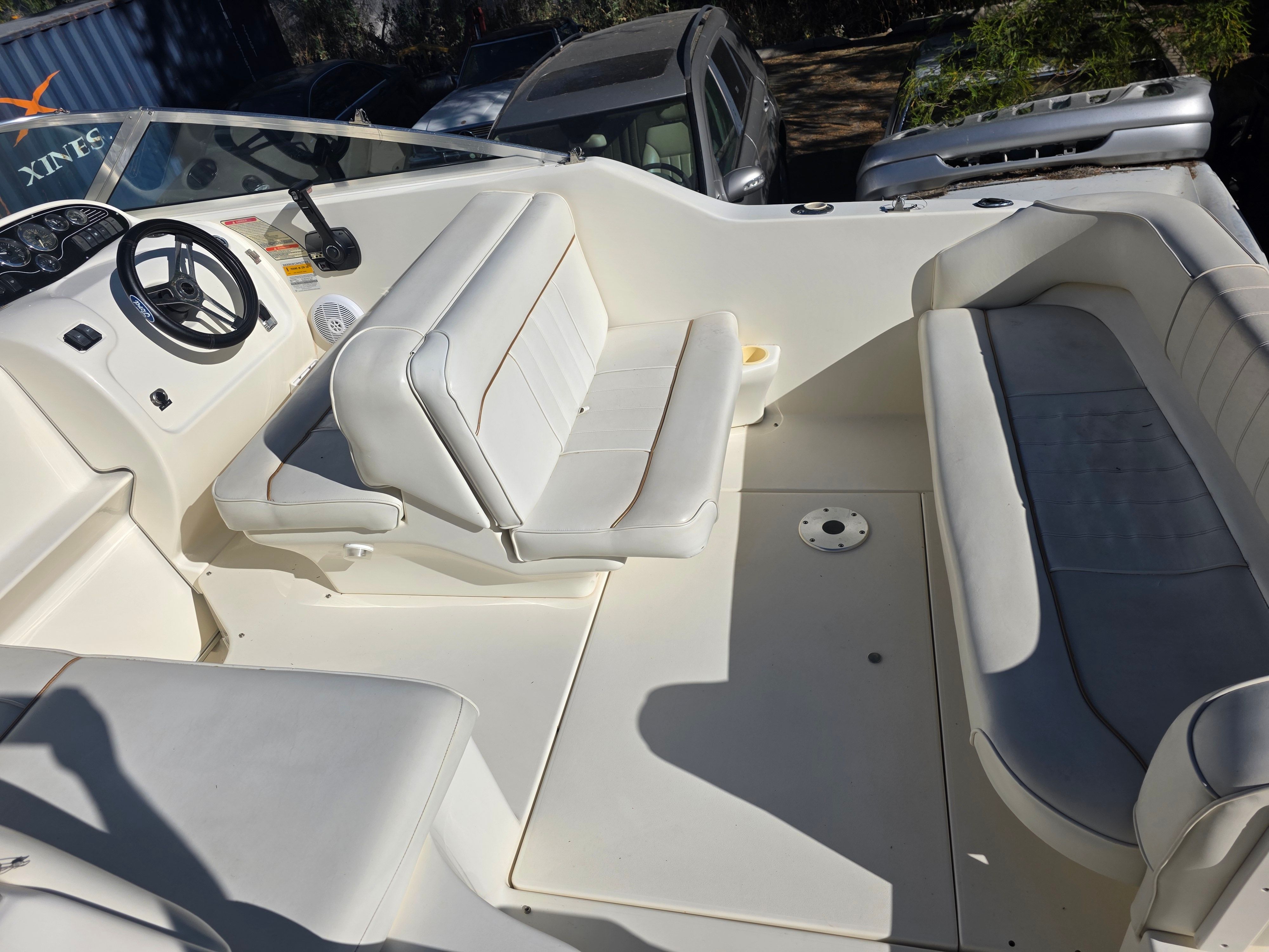 Interior of a 1997 Sea Ray 240 Sundeck with white seating and helm station.