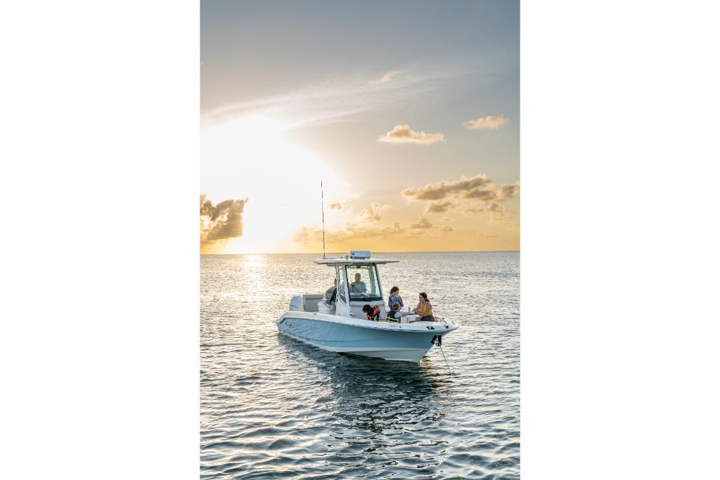 2024 Boston Whaler 280 Dauntless boat on water at sunset.
