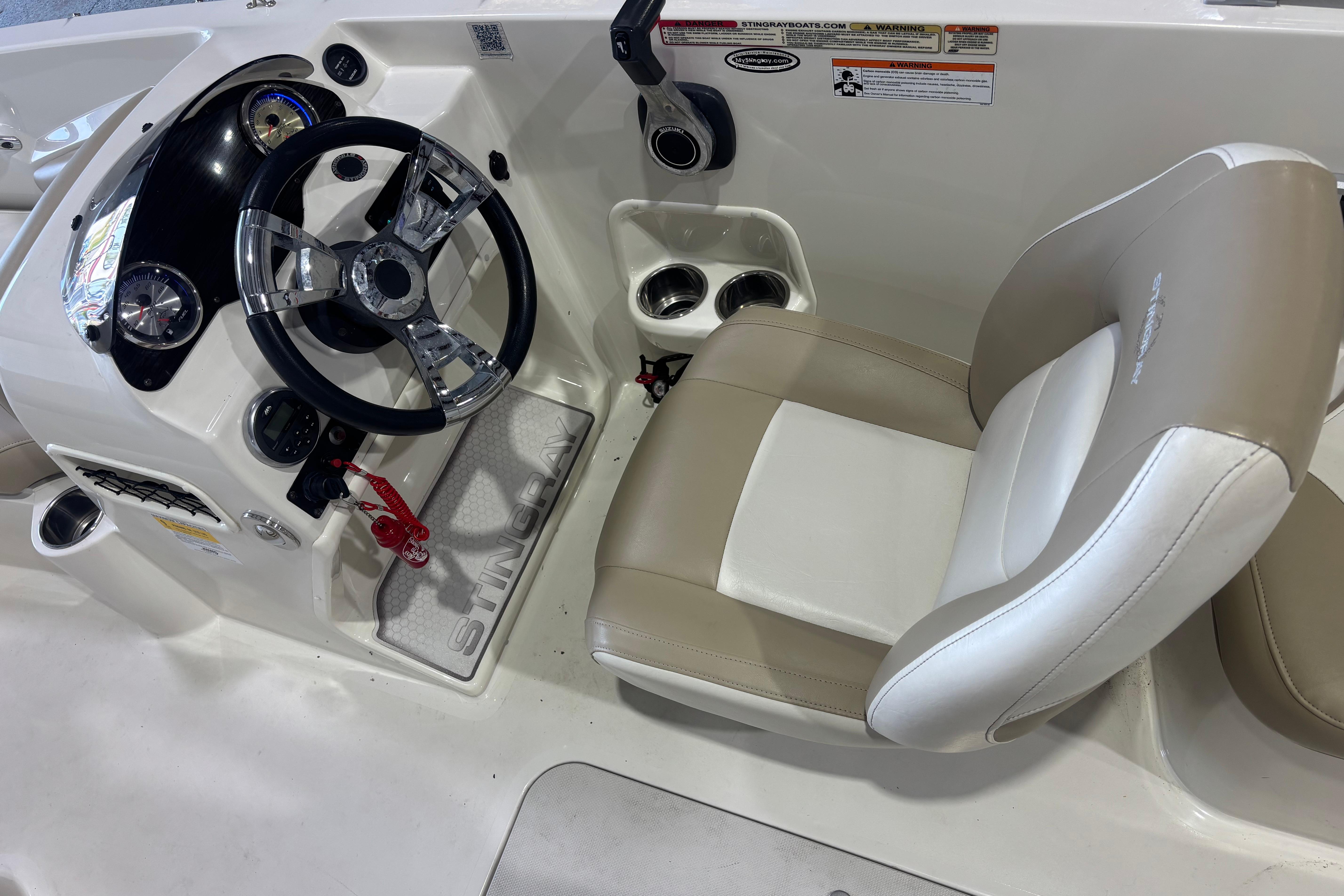 2017 Stingray 182 SC boat cockpit with steering wheel and beige seat.