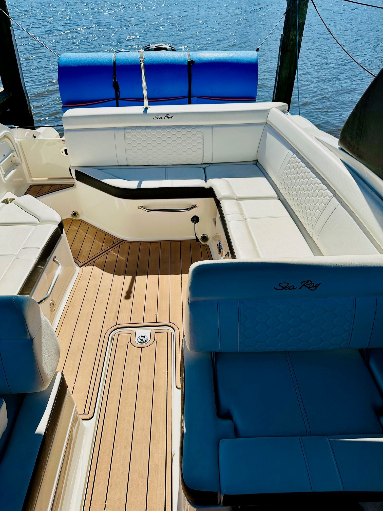 The image shows the cockpit of a Sea Ray SDX 270 Outboard with white upholstery and wood flooring.