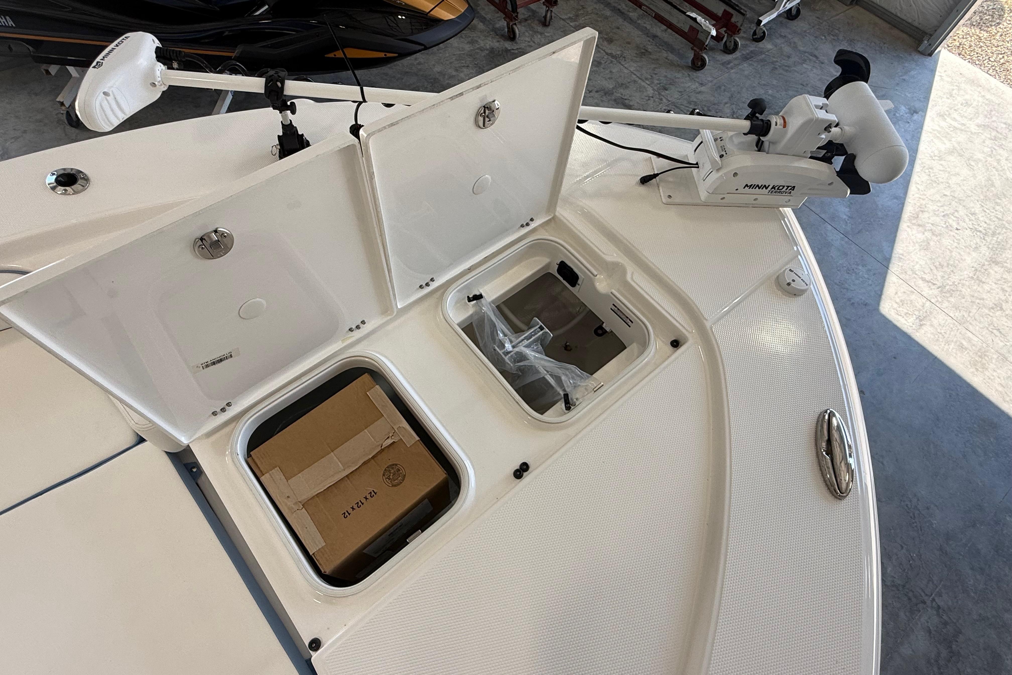 2026 Robalo 246 Cayman boat deck with storage compartments and Minn Kota trolling motor.
