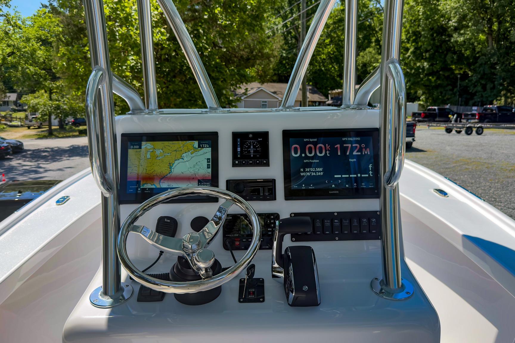 Boat dashboard with navigation screens and steering wheel, Weaver 25 model, 2025.