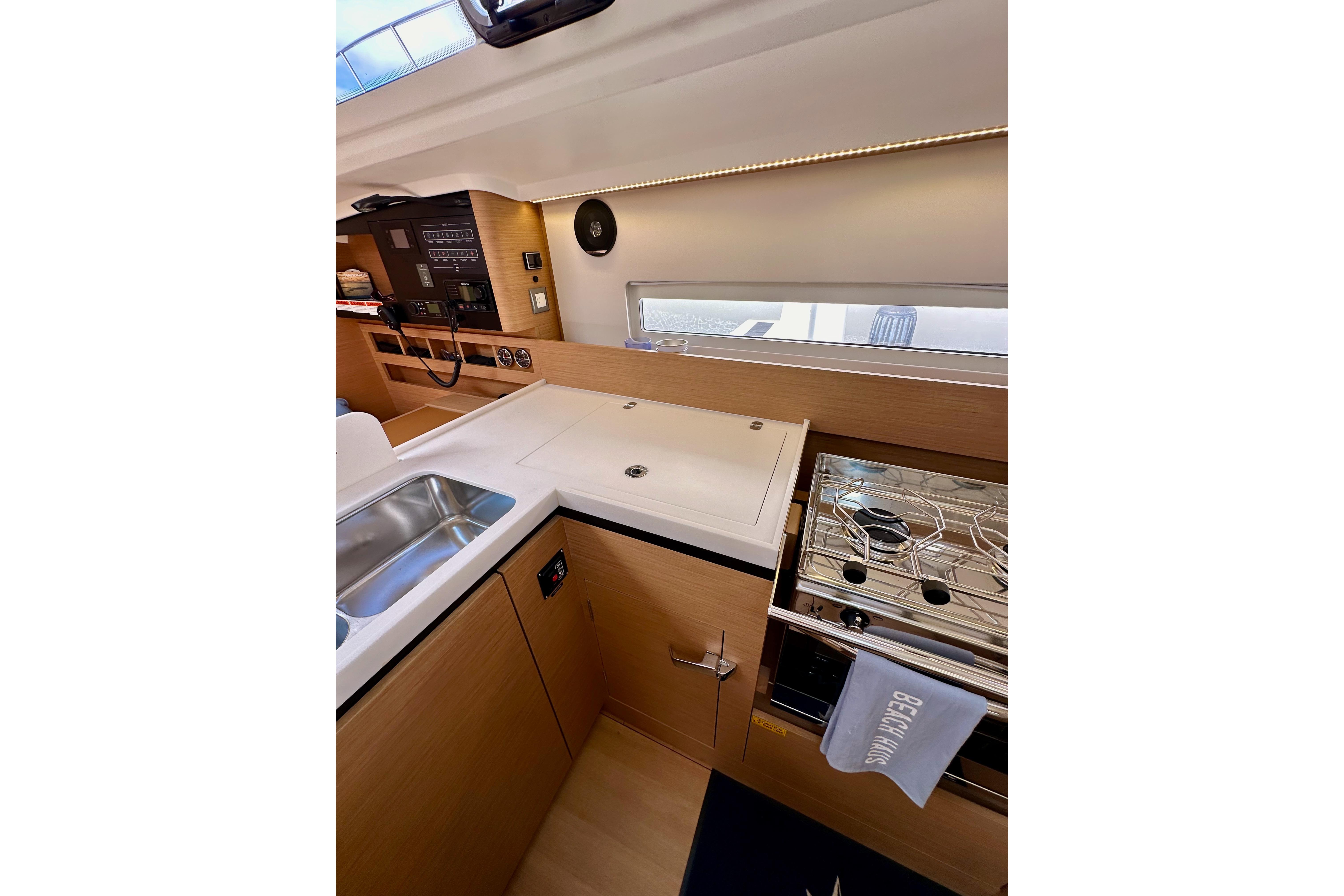 Modern kitchen interior of 2024 Jeanneau Sun Odyssey 410 yacht, featuring sleek design and appliances.
