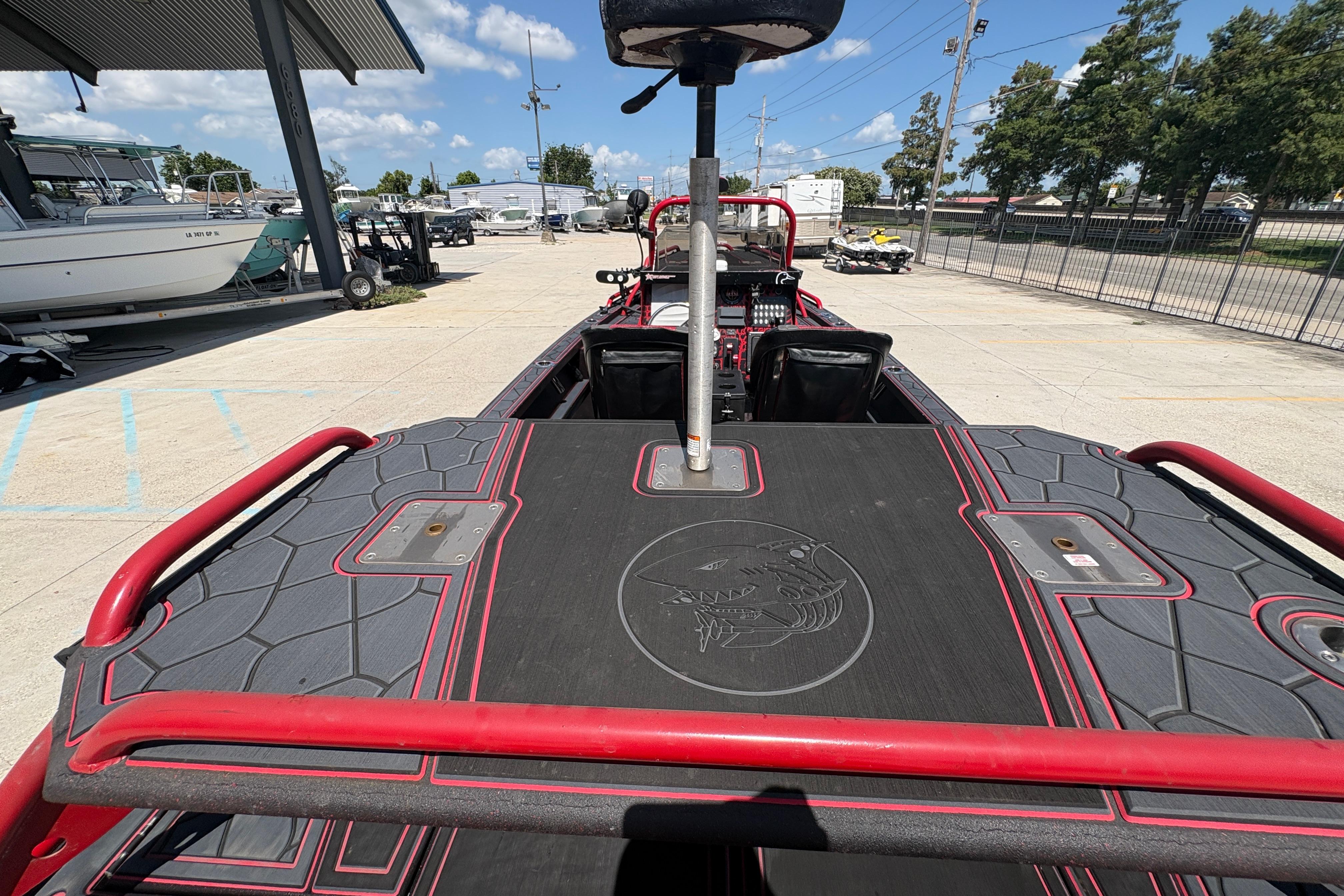 Custom 2018 Swamp Shark 24' boat with sleek black and red design, docked outdoors.