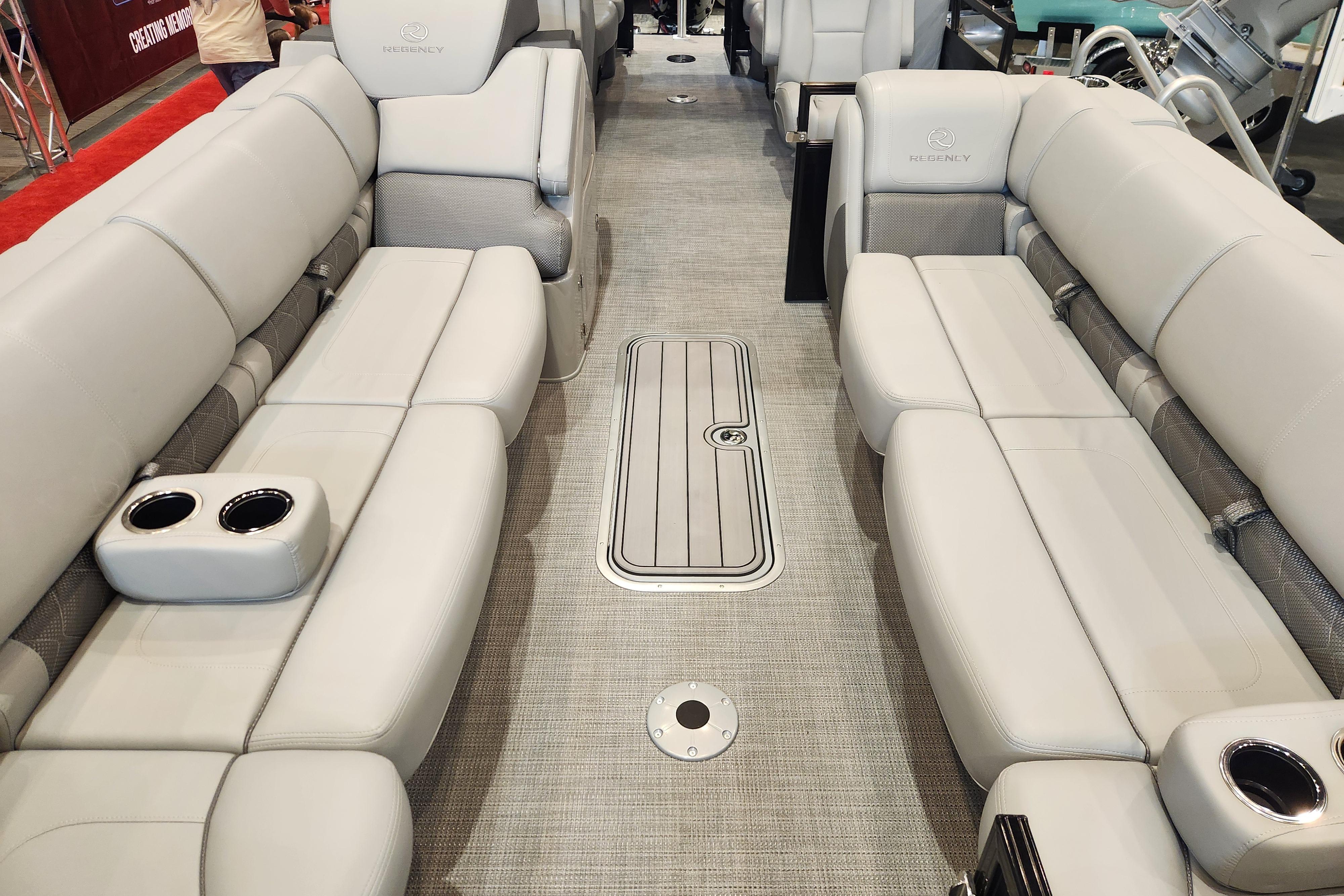 Luxurious interior of 2025 Regency 250 LE3 pontoon boat with plush seating and cup holders.
