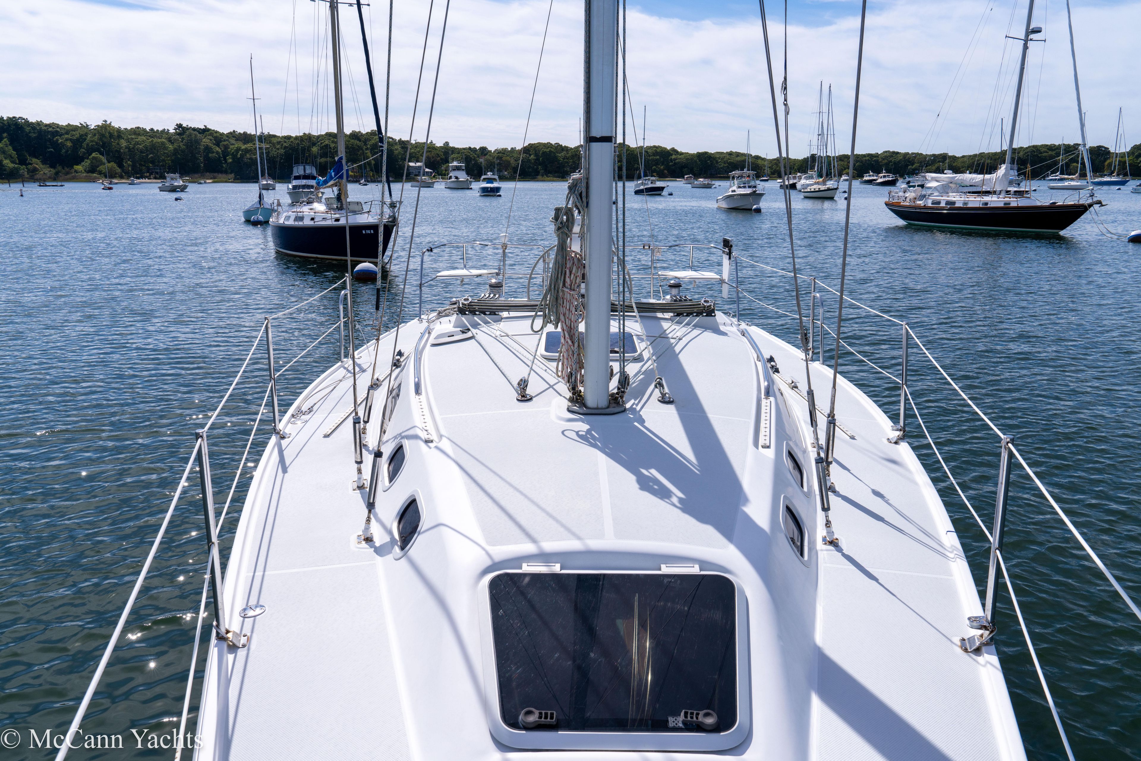 Catalina 320 sailboat on calm water, surrounded by other boats, 2003 model.