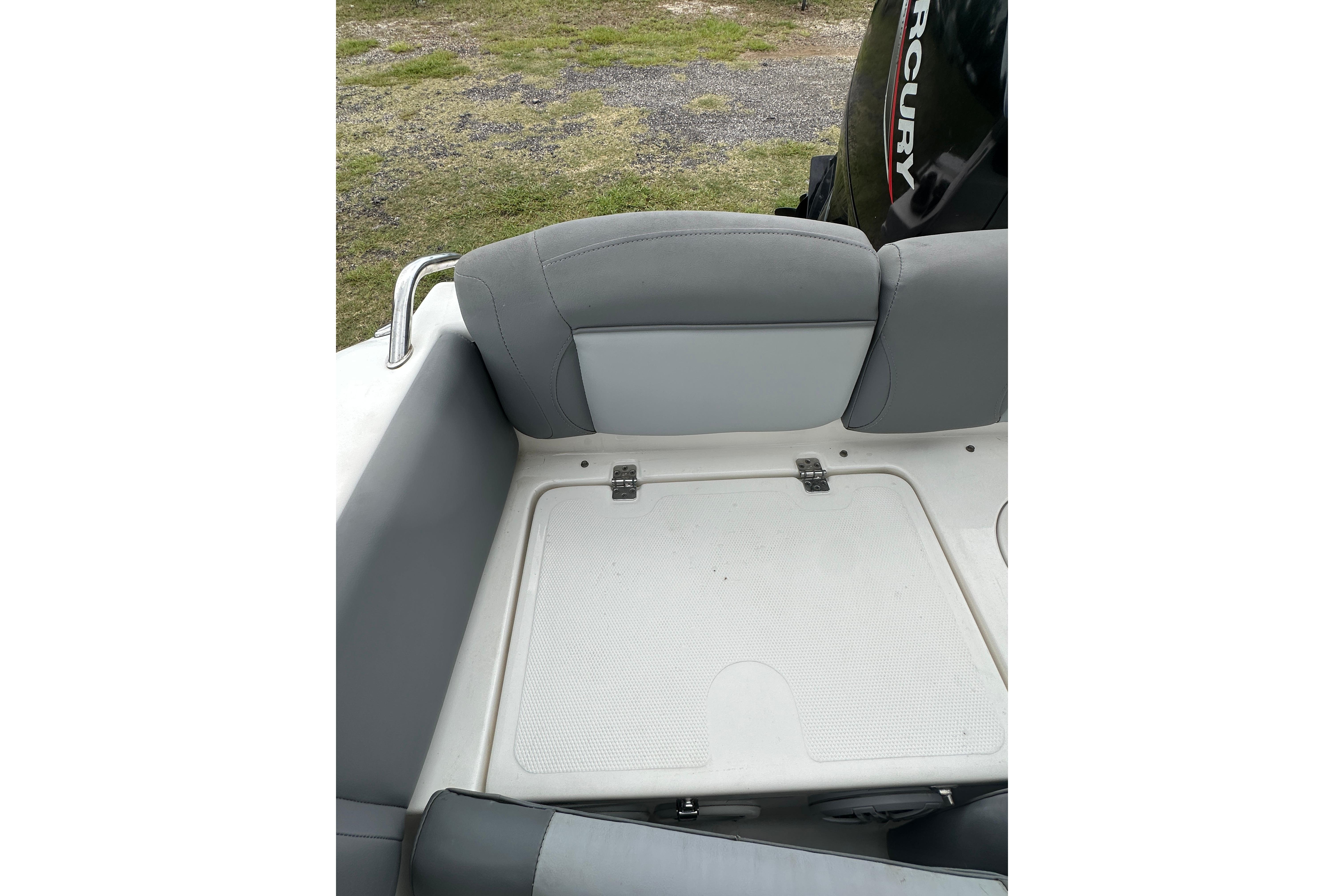 2023 NauticStar 2102 Legacy boat seating with storage compartment and Mercury engine.