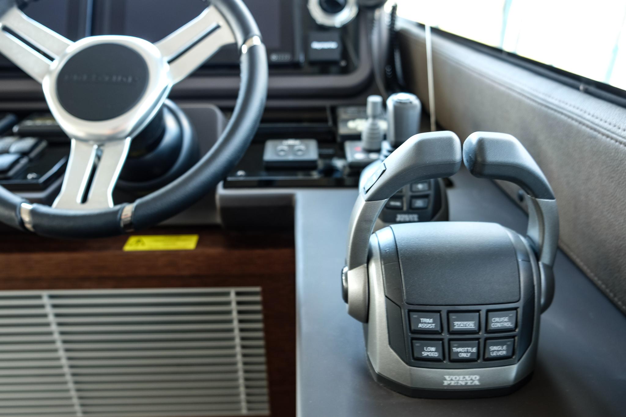 2024 Prestige 520 Flybridge helm with Volvo Penta controls and steering wheel.