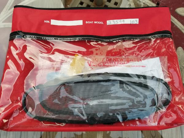 Red waterproof bag with documents for a 2011 Boston Whaler 235 Conquest boat.