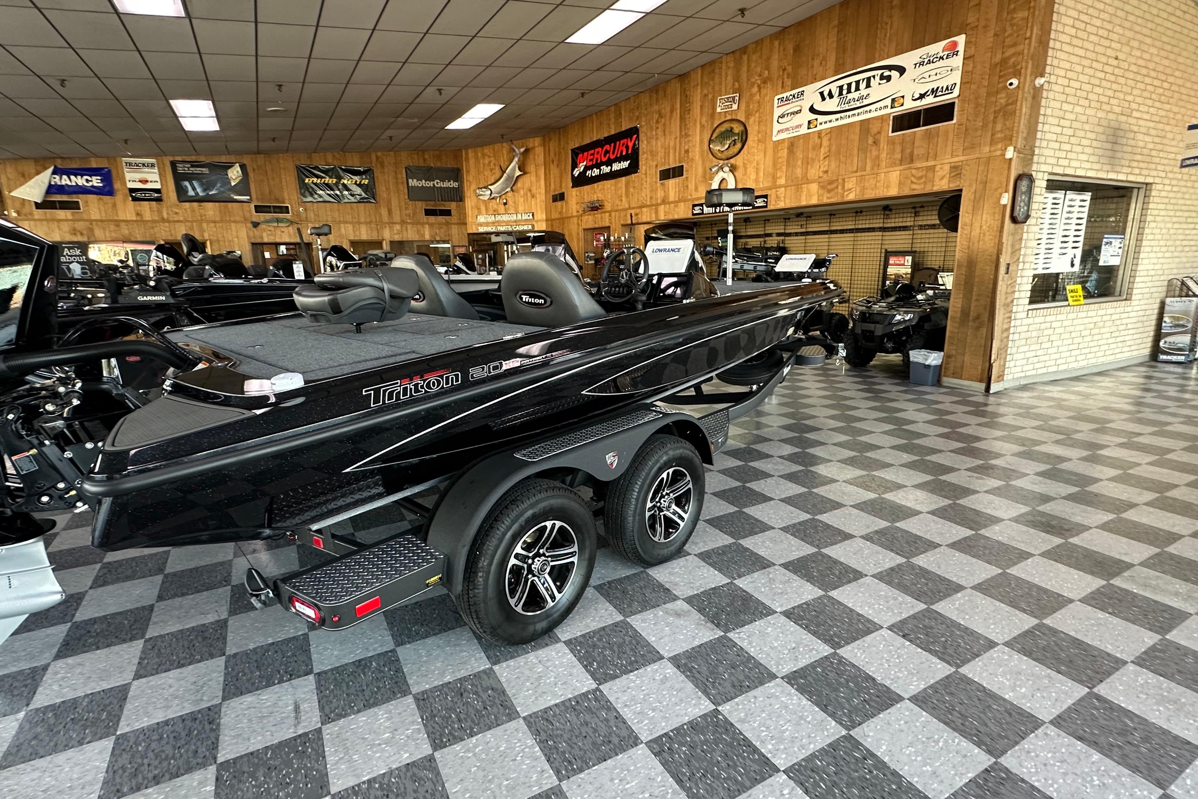 2026 Triton 20XP Patriot boat displayed in showroom with checkered flooring.