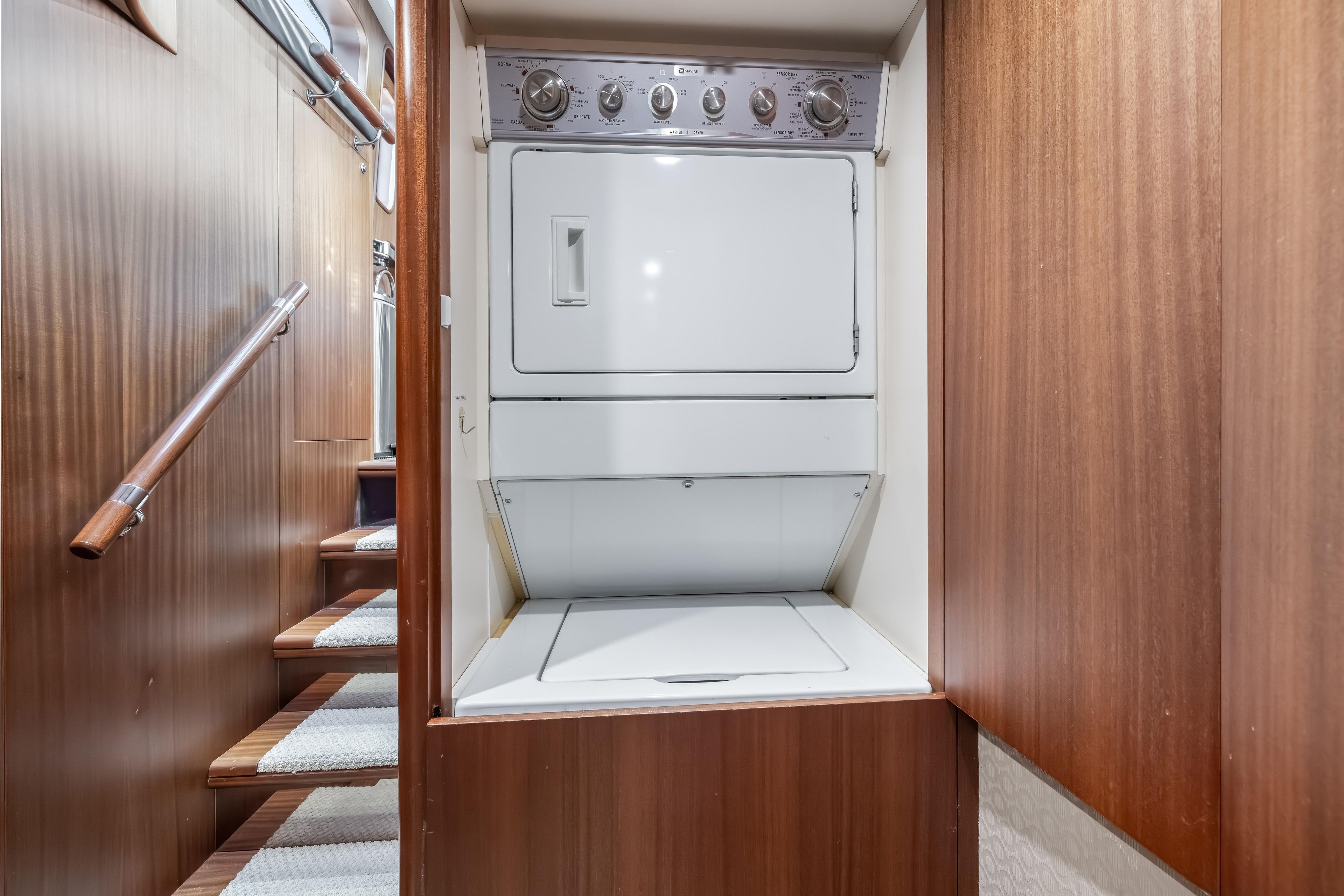 Laundry area with stacked washer and dryer on 2012 Cheoy Lee 84 Bravo yacht.