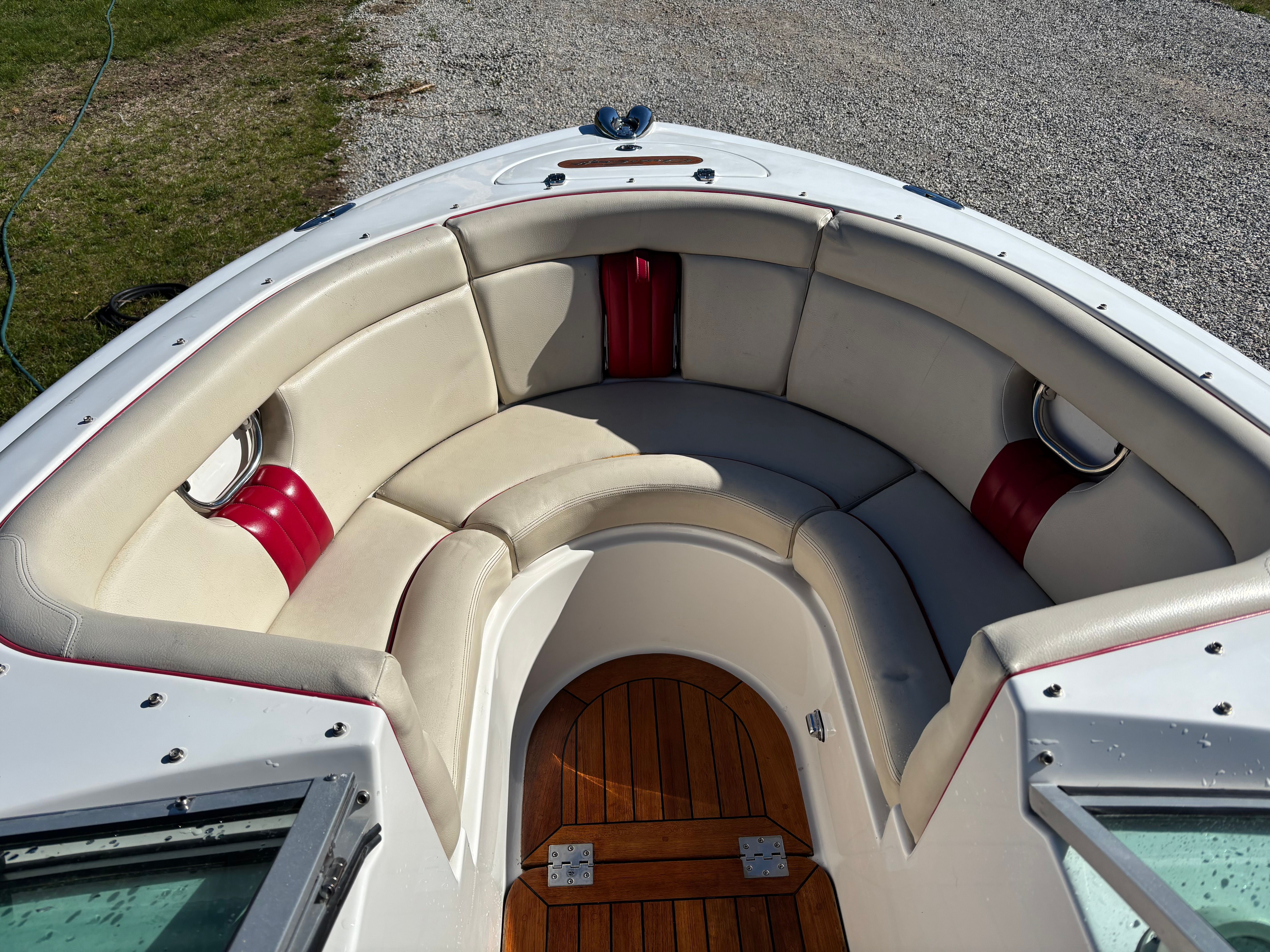 The image shows the bow of a Chris-Craft Launch 22 boat with beige seating and wooden flooring.