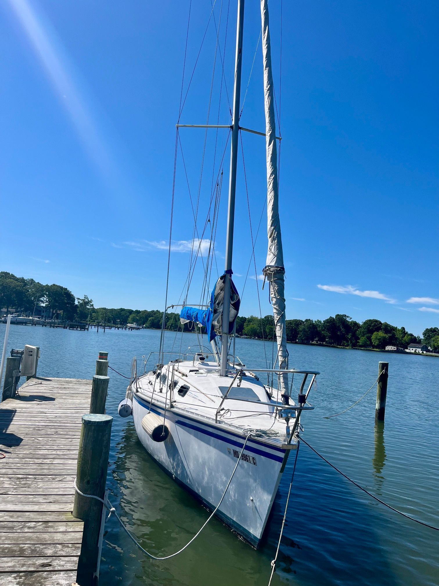 1985 Hunter 30 sailboat docked in calm waters under a clear blue sky.