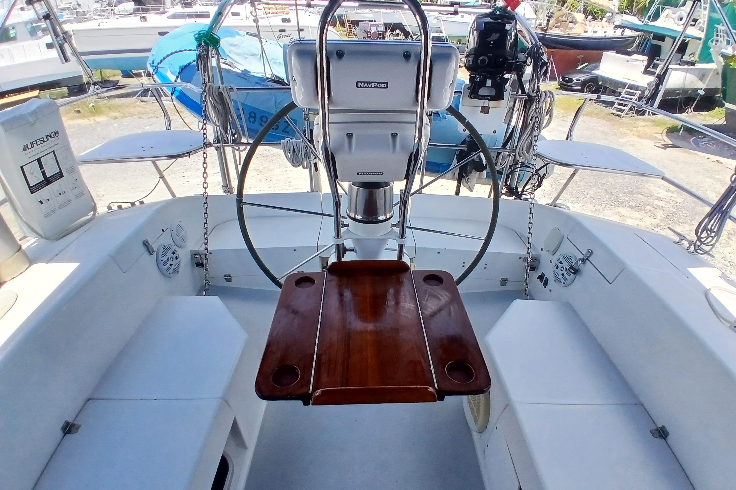 Cockpit of a 1995 Catalina 42 MkII sailboat with wooden table and steering wheel.