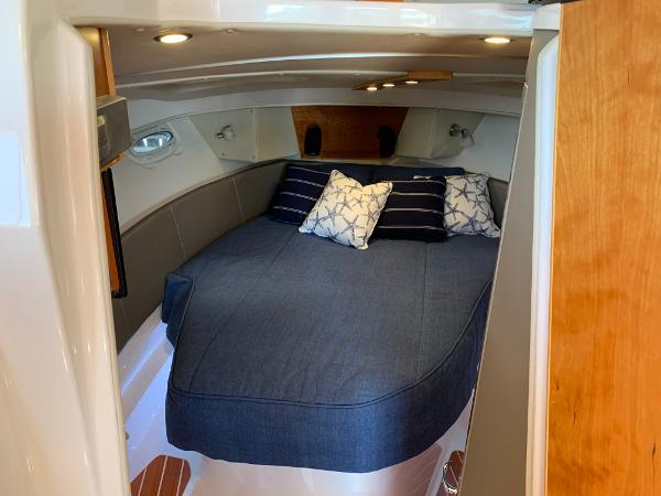 2021 Cutwater C-32 CB cabin interior with cozy bed and decorative pillows.