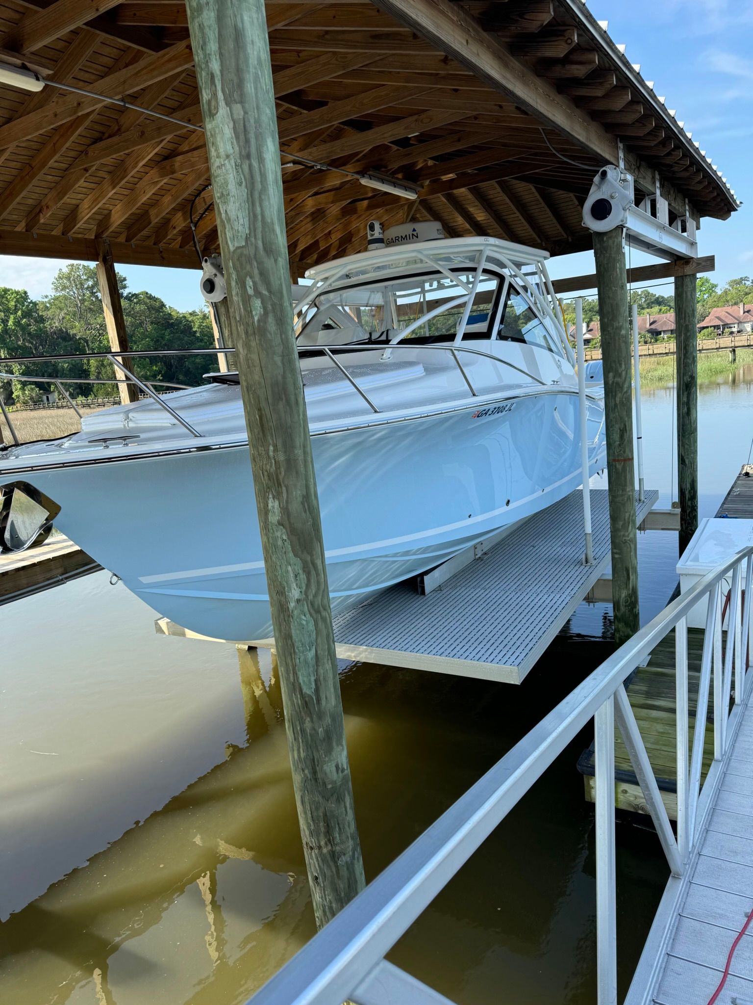 A 2024 Albemarle 30 Express boat is lifted in a covered dock.