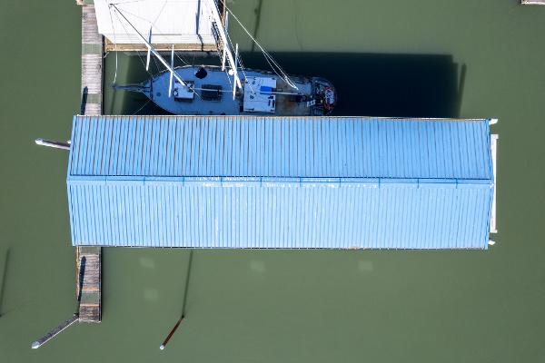 Aerial view of 1985 Custom Larson Boathouse with sailboat docked underneath.