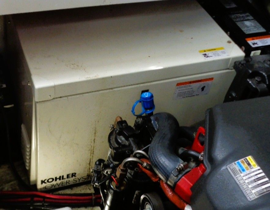 An engine compartment with a Kohler generator system and engine components.