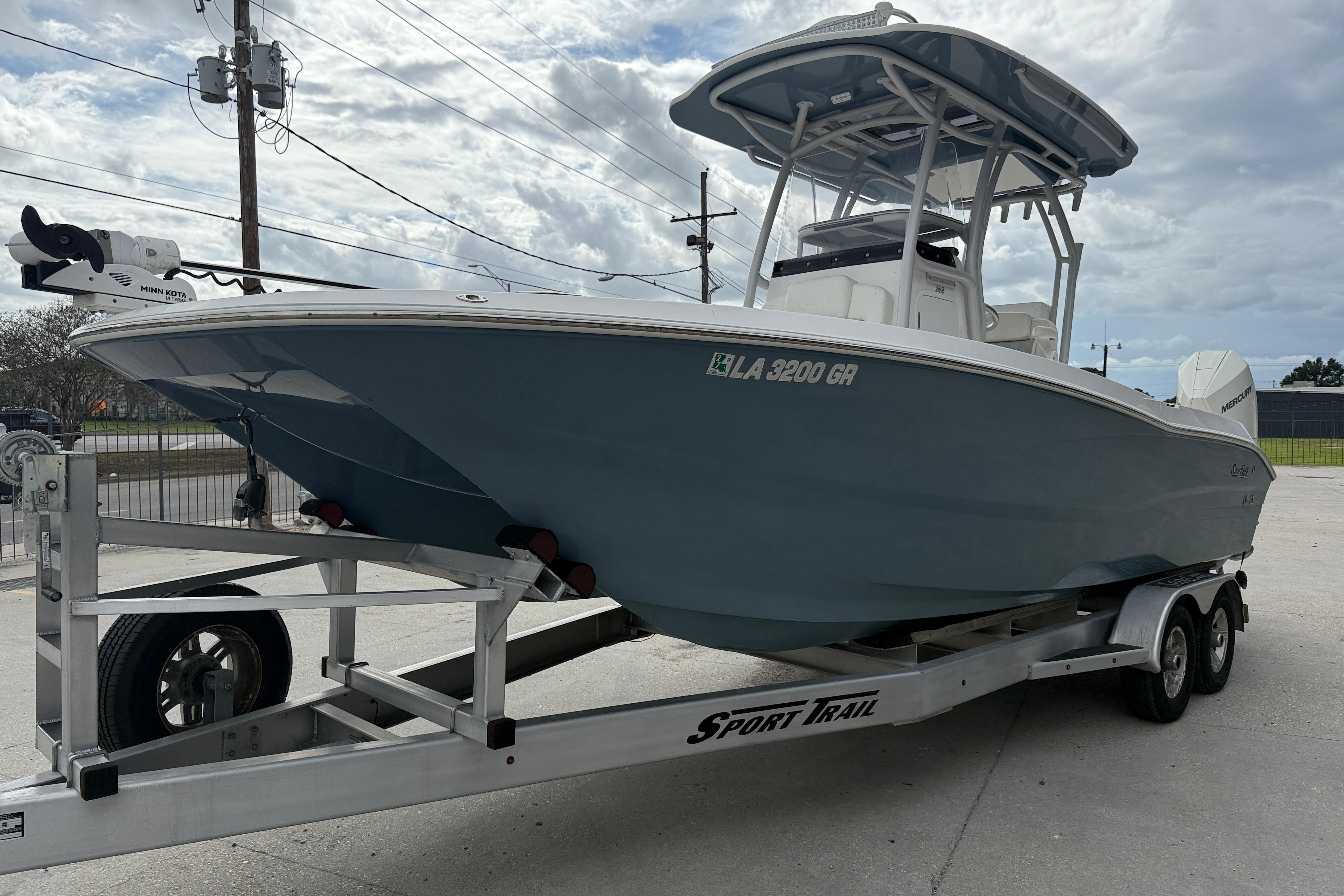 2021 Sea Cat 260 boat on trailer, parked outdoors under cloudy sky.