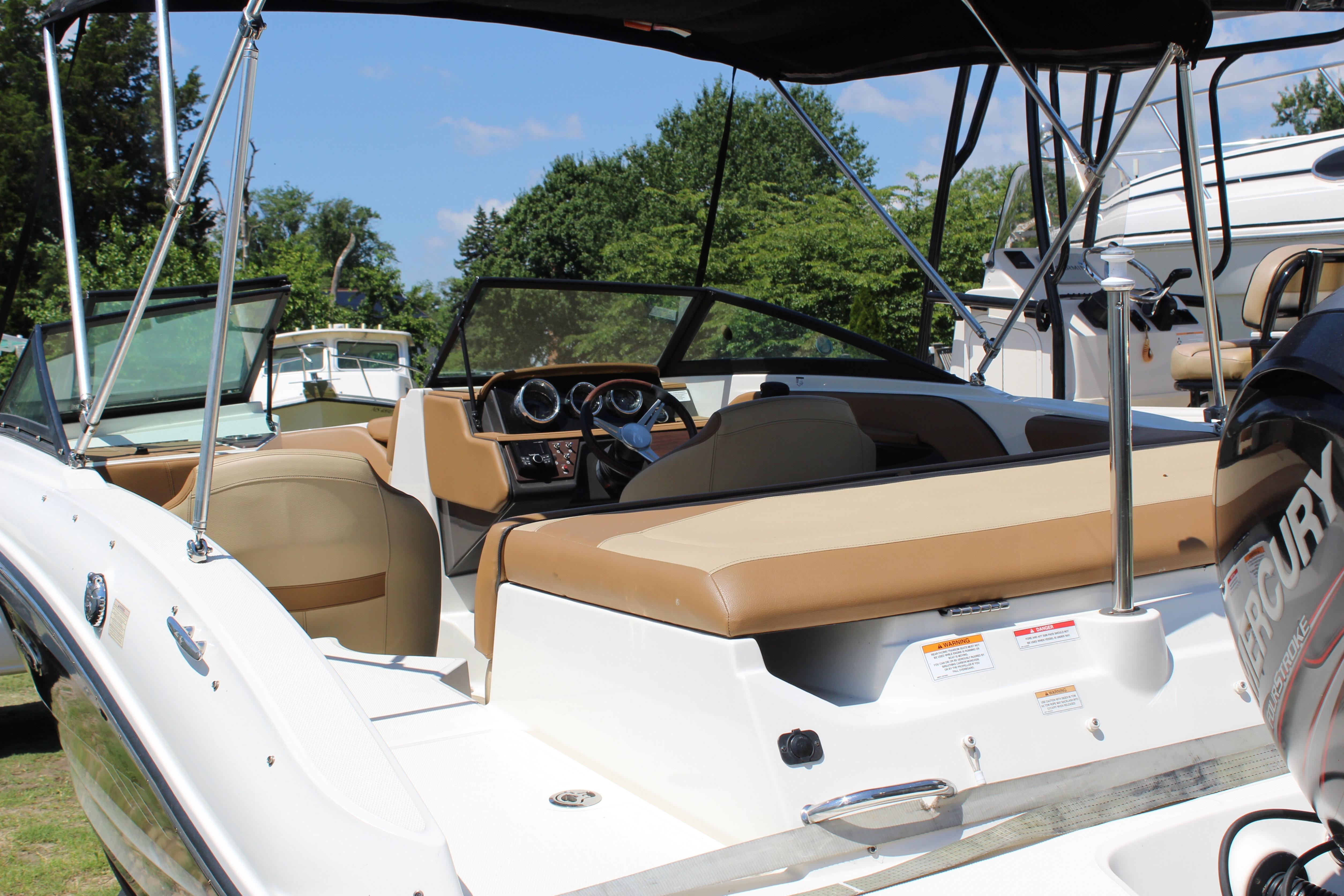2018 Sea Ray SPX 190 Outboard boat with tan seating and Mercury engine, docked outdoors.