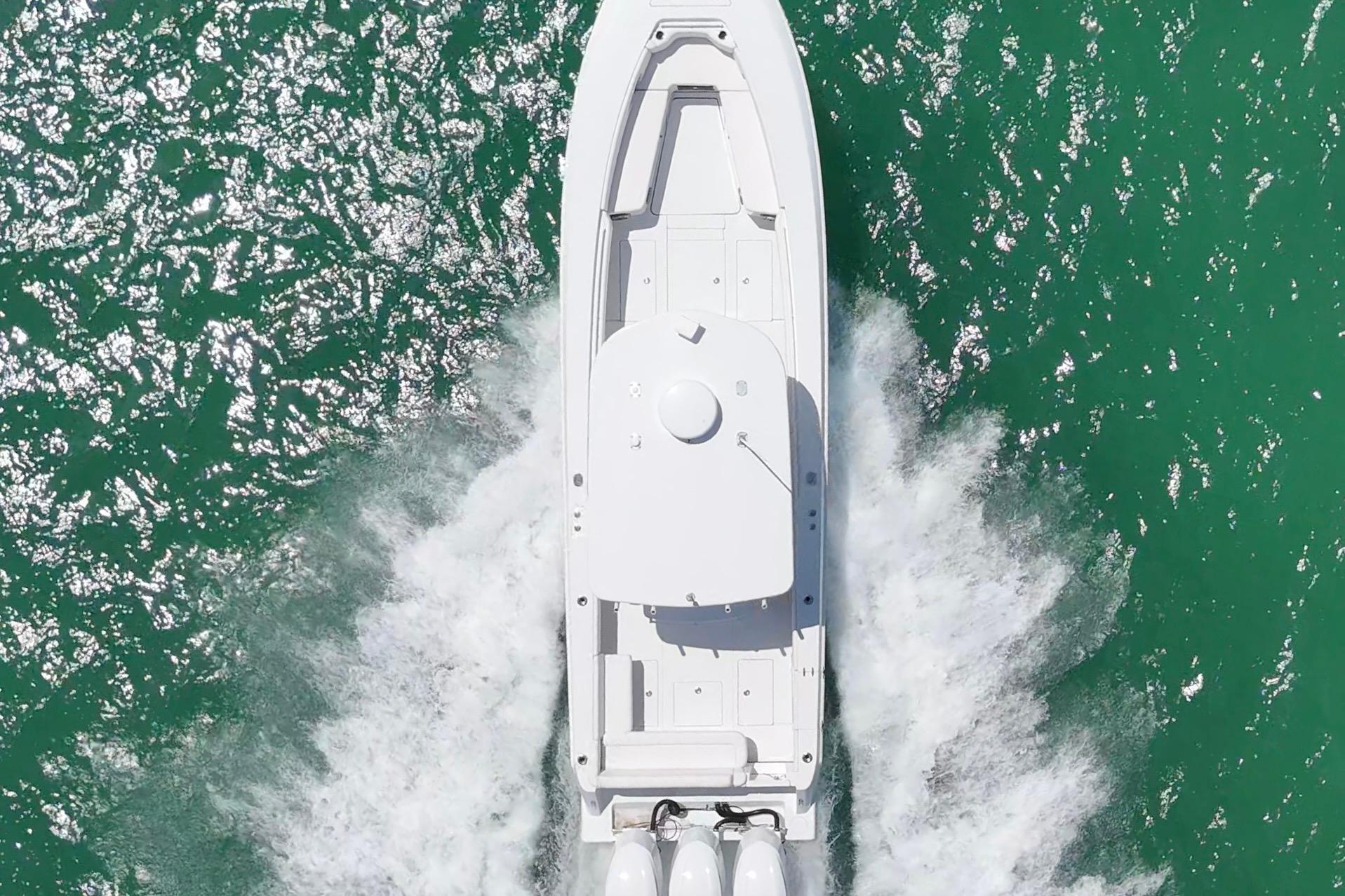 Aerial view of 2013 Contender 35 LS boat cruising on turquoise water.