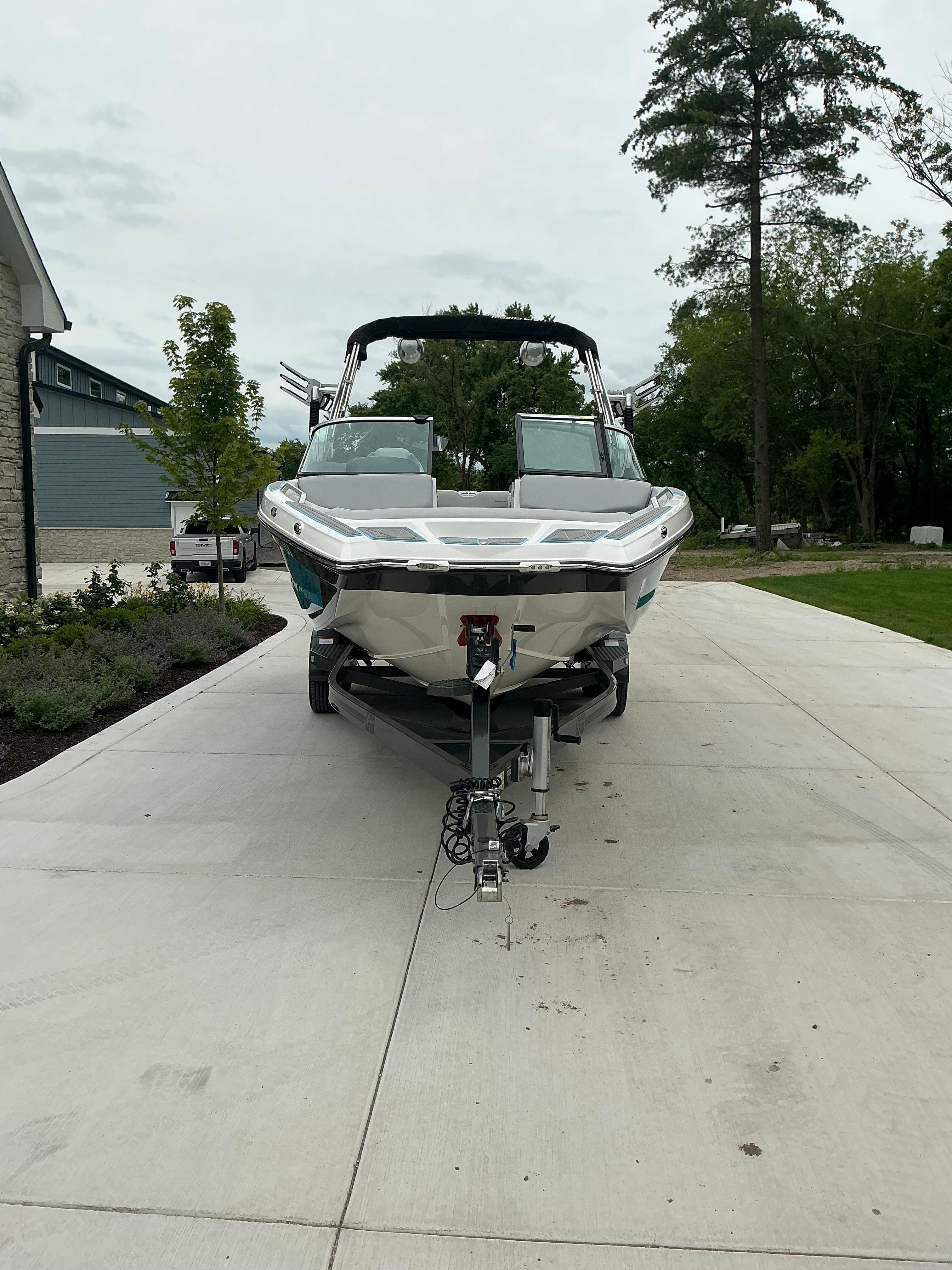 A 2019 MasterCraft XT22 boat on a trailer in a driveway.
