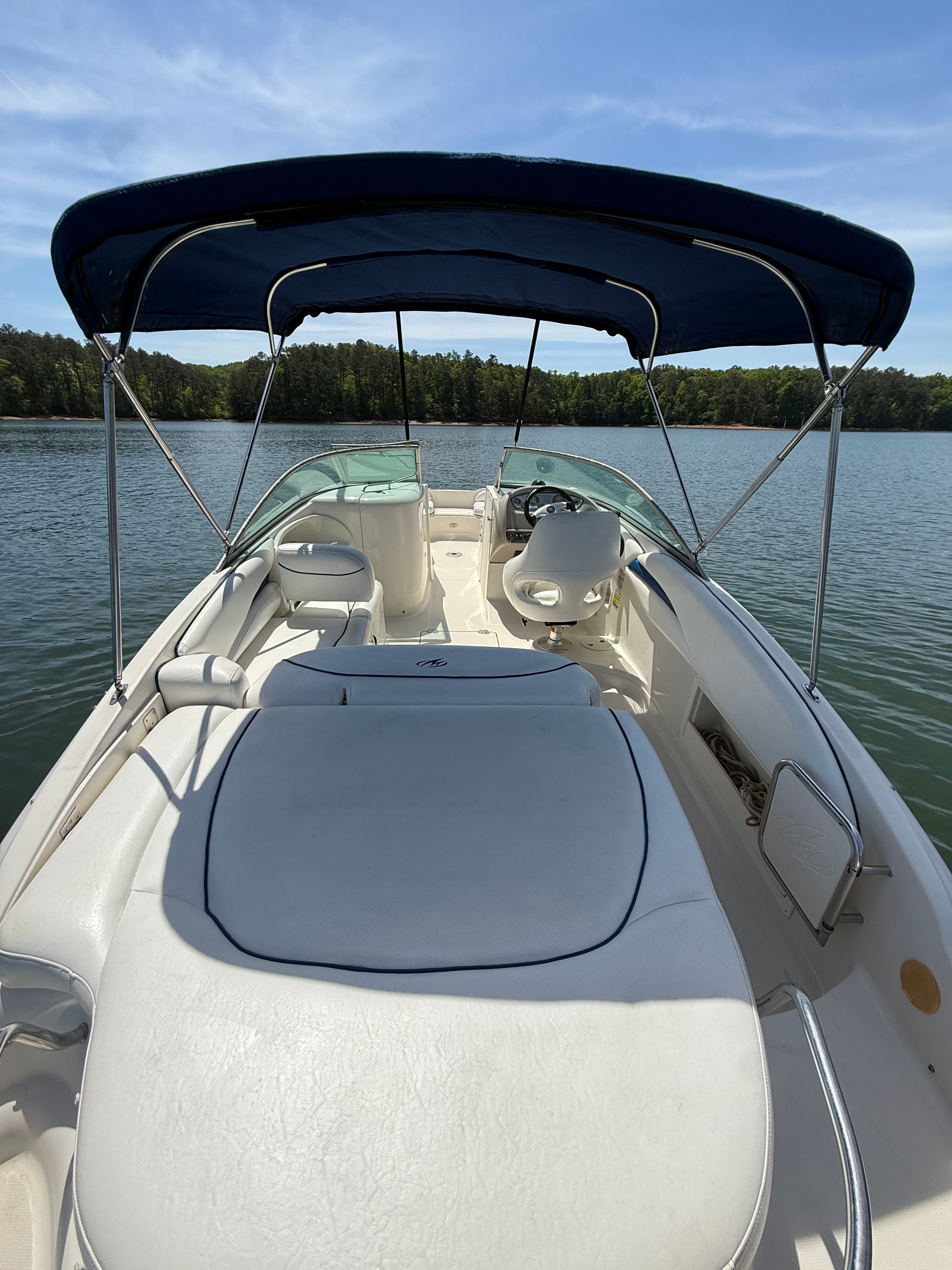 The image shows a 2005 Monterey 223 Explorer Sport boat with a blue canopy on calm water.