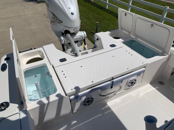 2024 Robalo 266 Cayman boat deck with storage compartments and outboard motor.