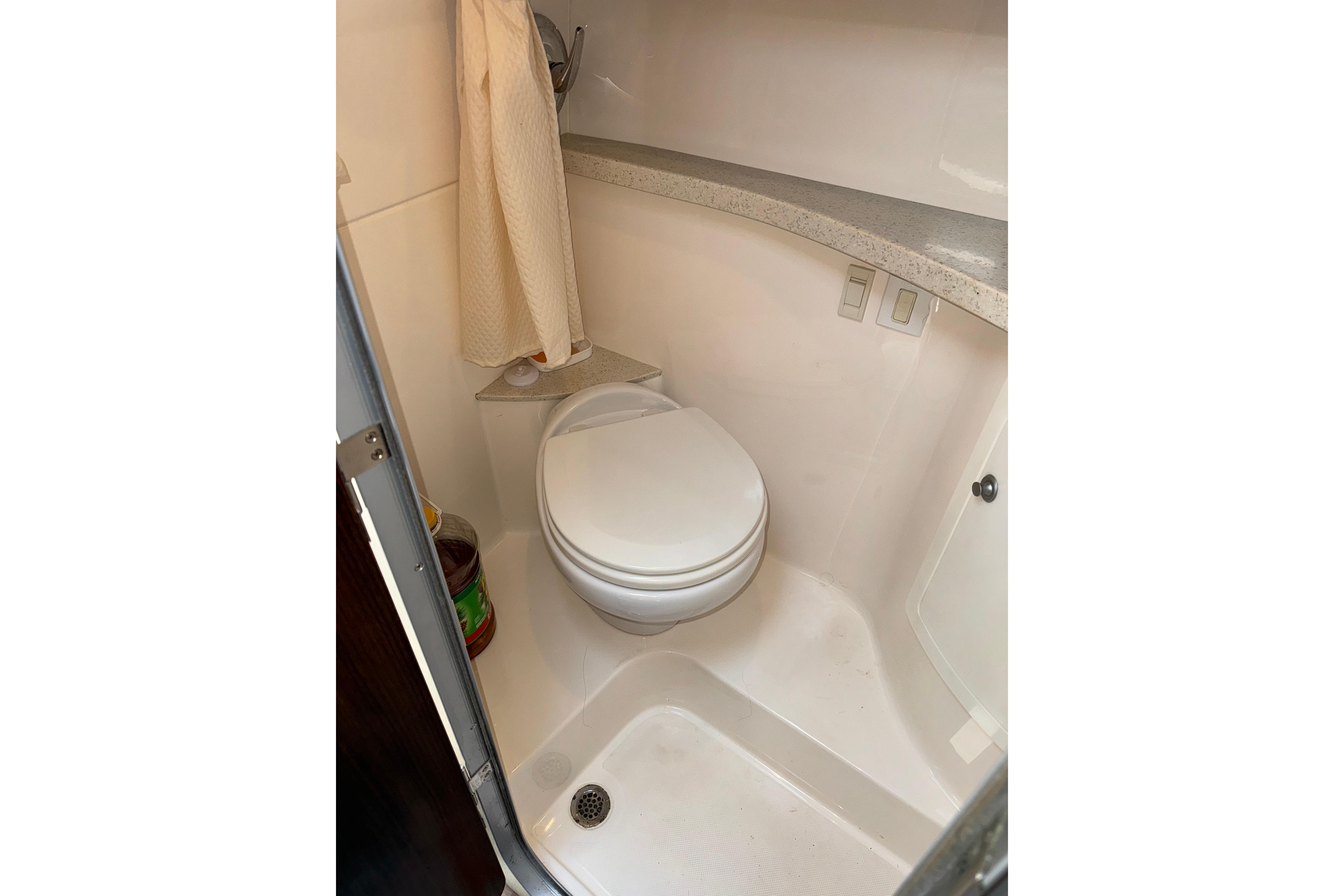 Bathroom interior of 2017 Regal 28 Express boat, featuring a compact toilet and shower area.