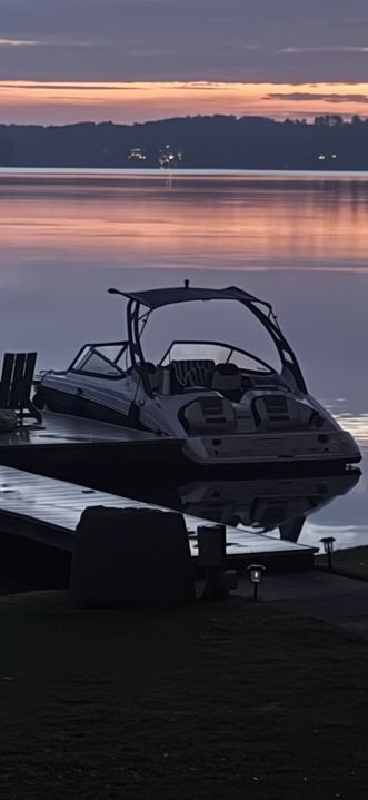 Yamaha 212SD boat on a calm lake at sunset.