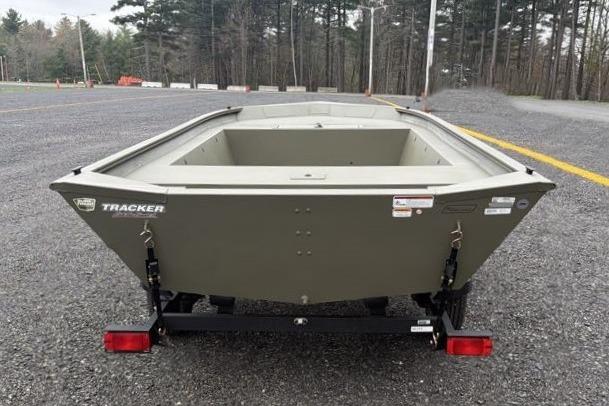 2026 Tracker Grizzly 1754 Utility boat on trailer, parked on gravel lot.