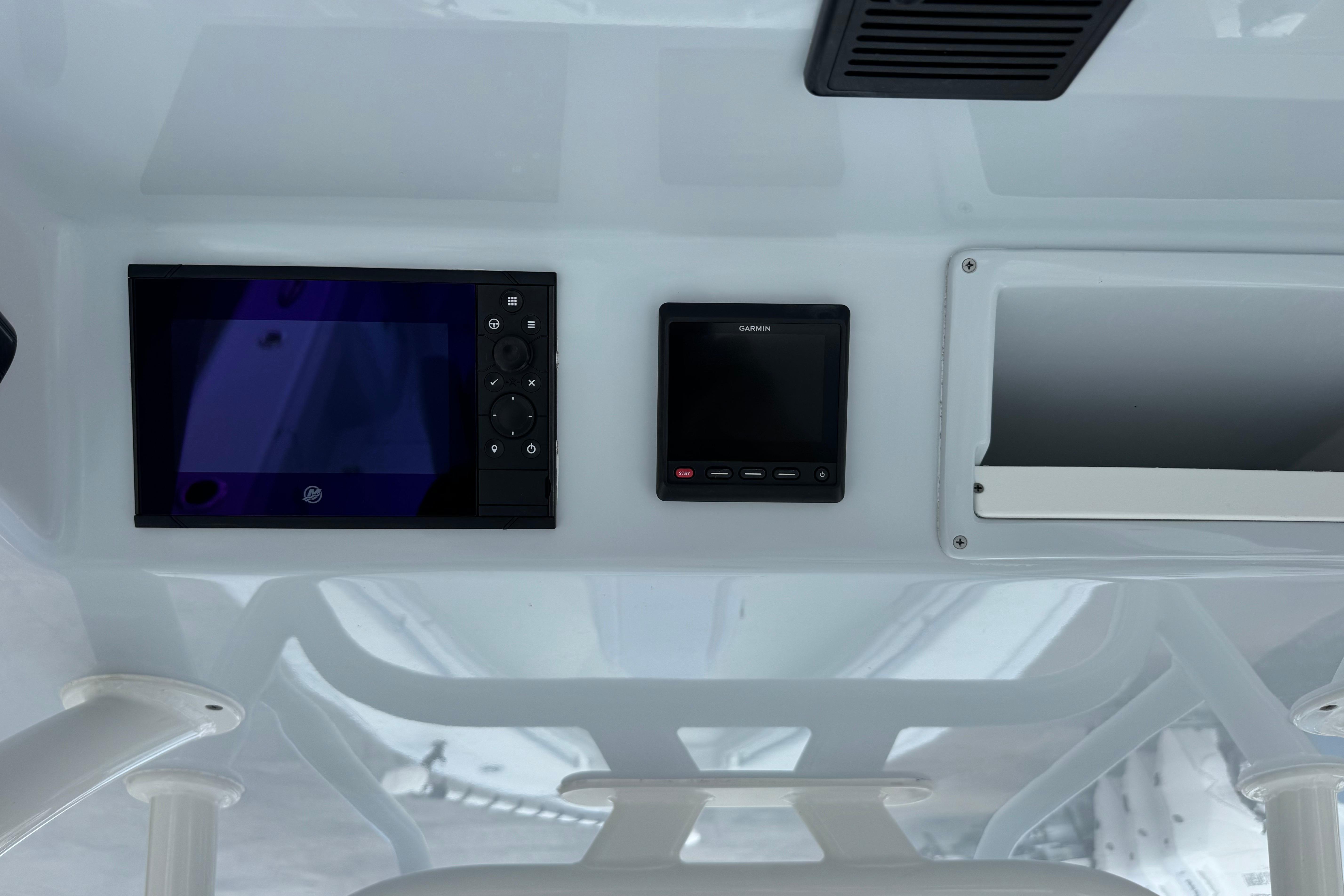 2022 Yellowfin 32 Offshore boat dashboard with electronic displays and storage compartment.