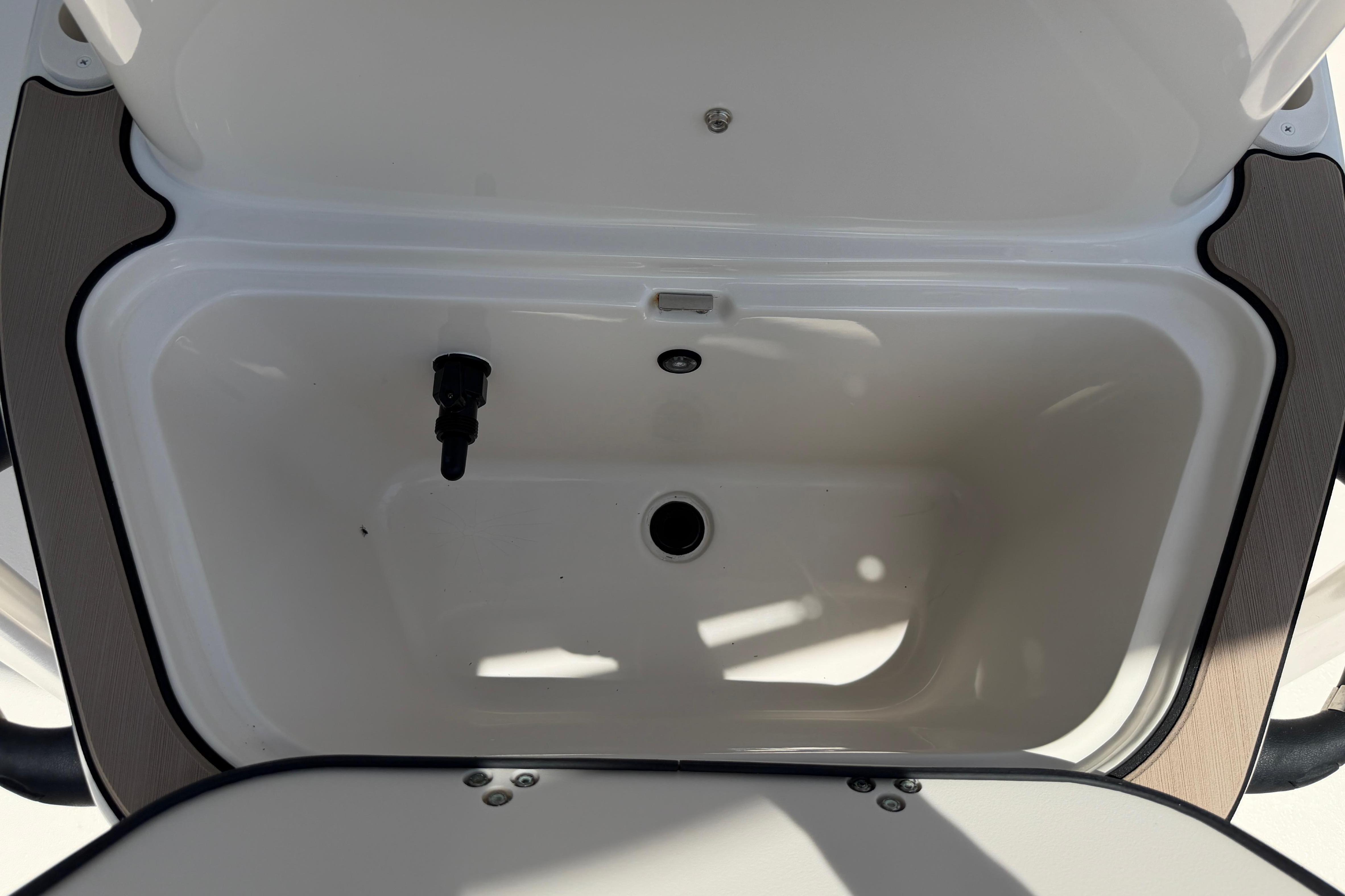 2023 Carolina Skiff 21 LS boat storage compartment, open lid, white interior.