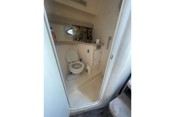 2000 Rinker Fiesta Vee 310 boat bathroom interior with toilet and sink.