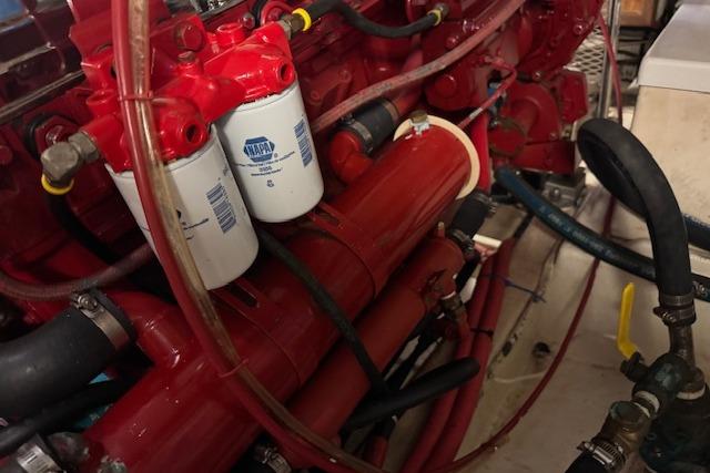 Engine components of a 1986 Krogen 42 Classic, featuring red filters and hoses.