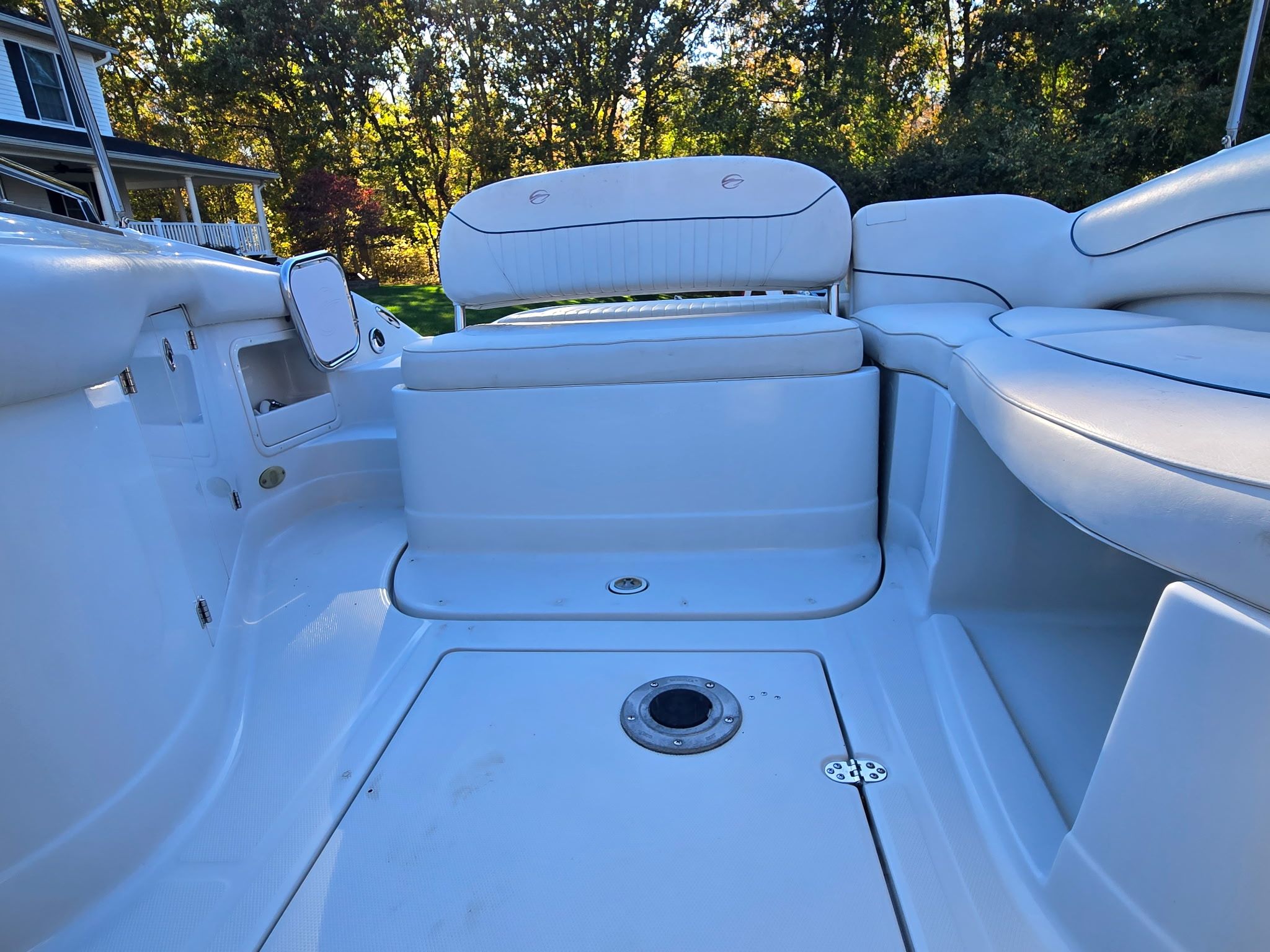 The image shows the cockpit of a 2005 Crownline 240 EX boat with white upholstery.