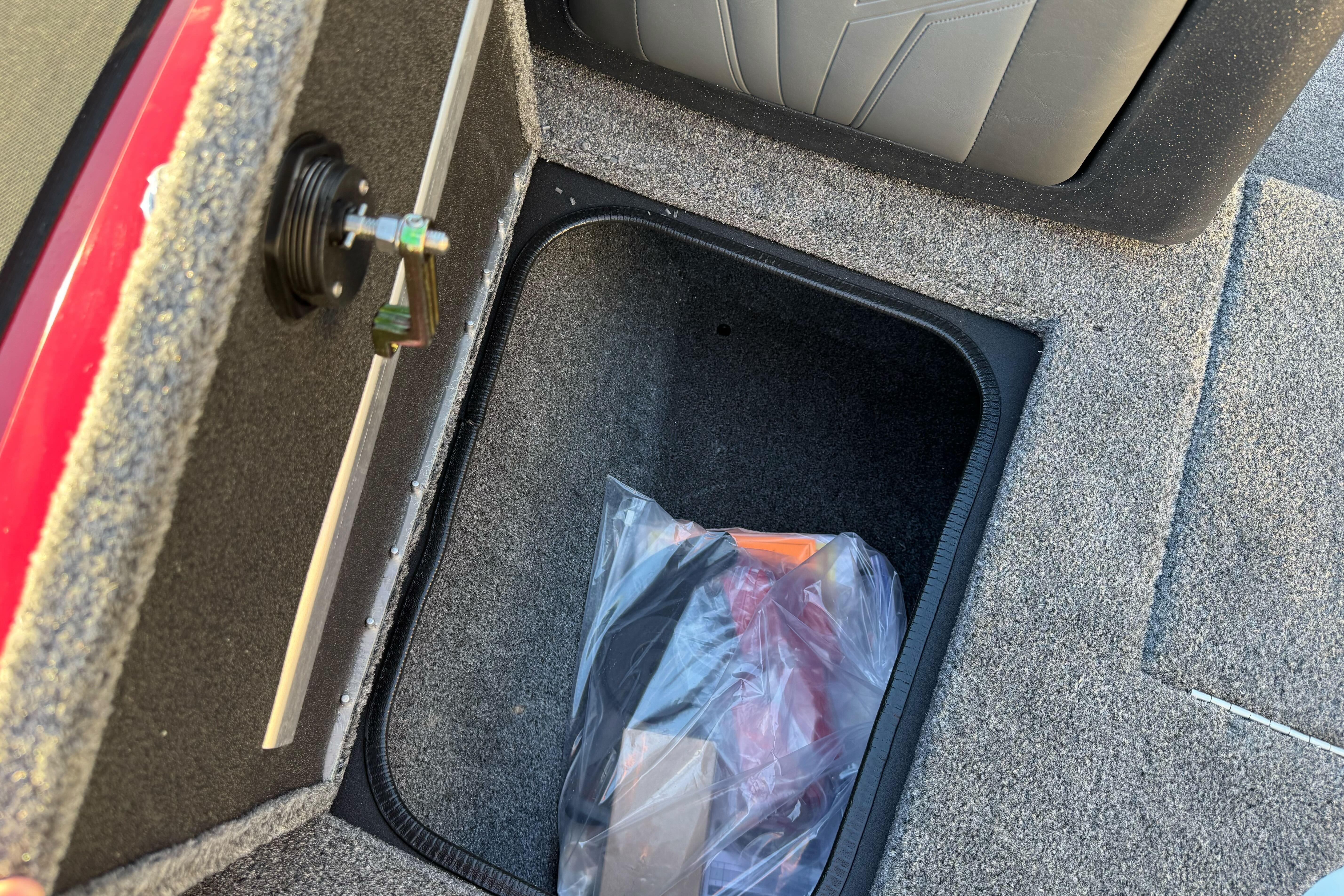 Storage compartment in 2026 Tracker Targa V-18 WT boat, featuring carpeted interior and latch.