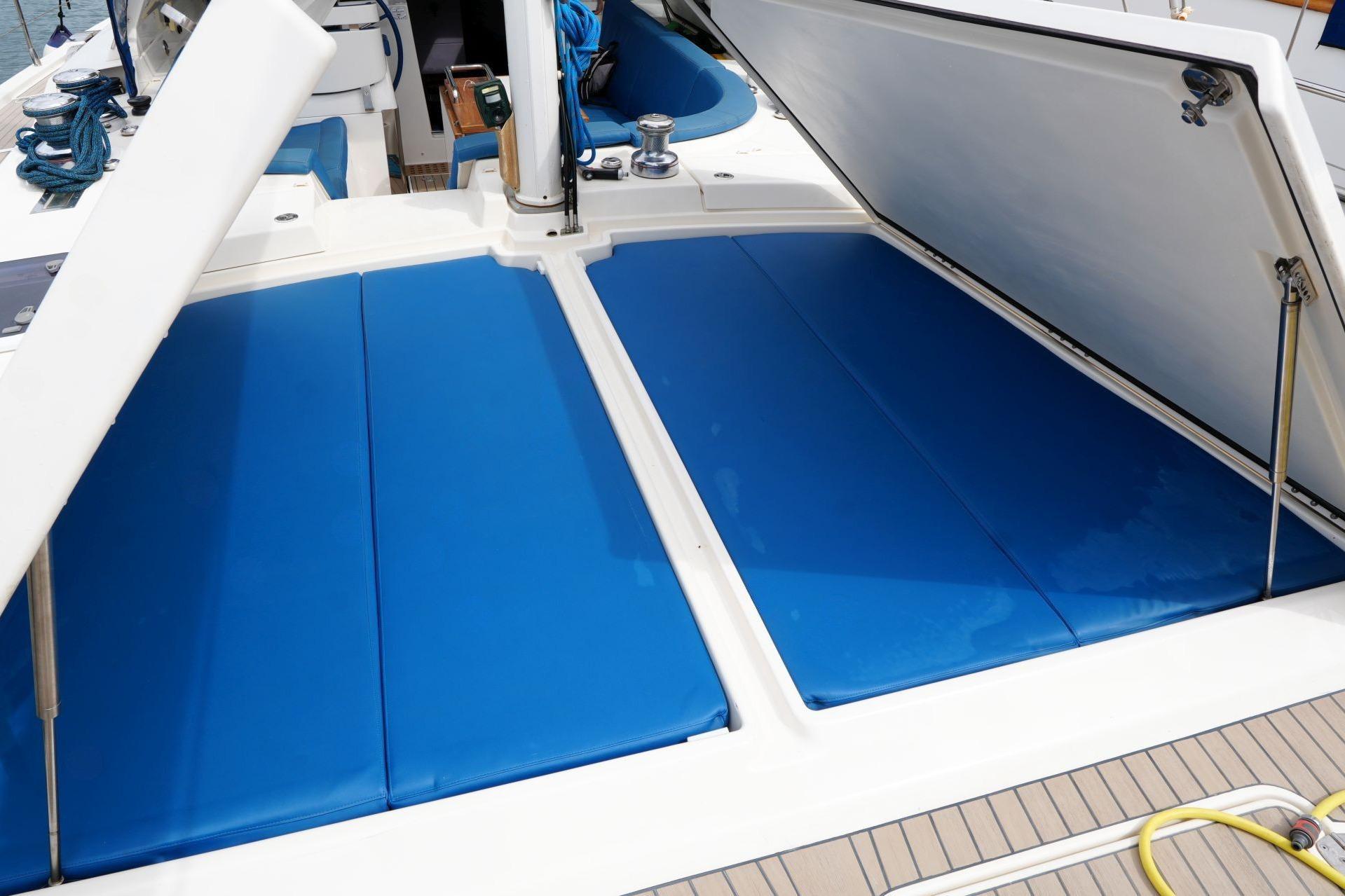 2018 Amel 64 yacht with open deck storage and blue cushions.