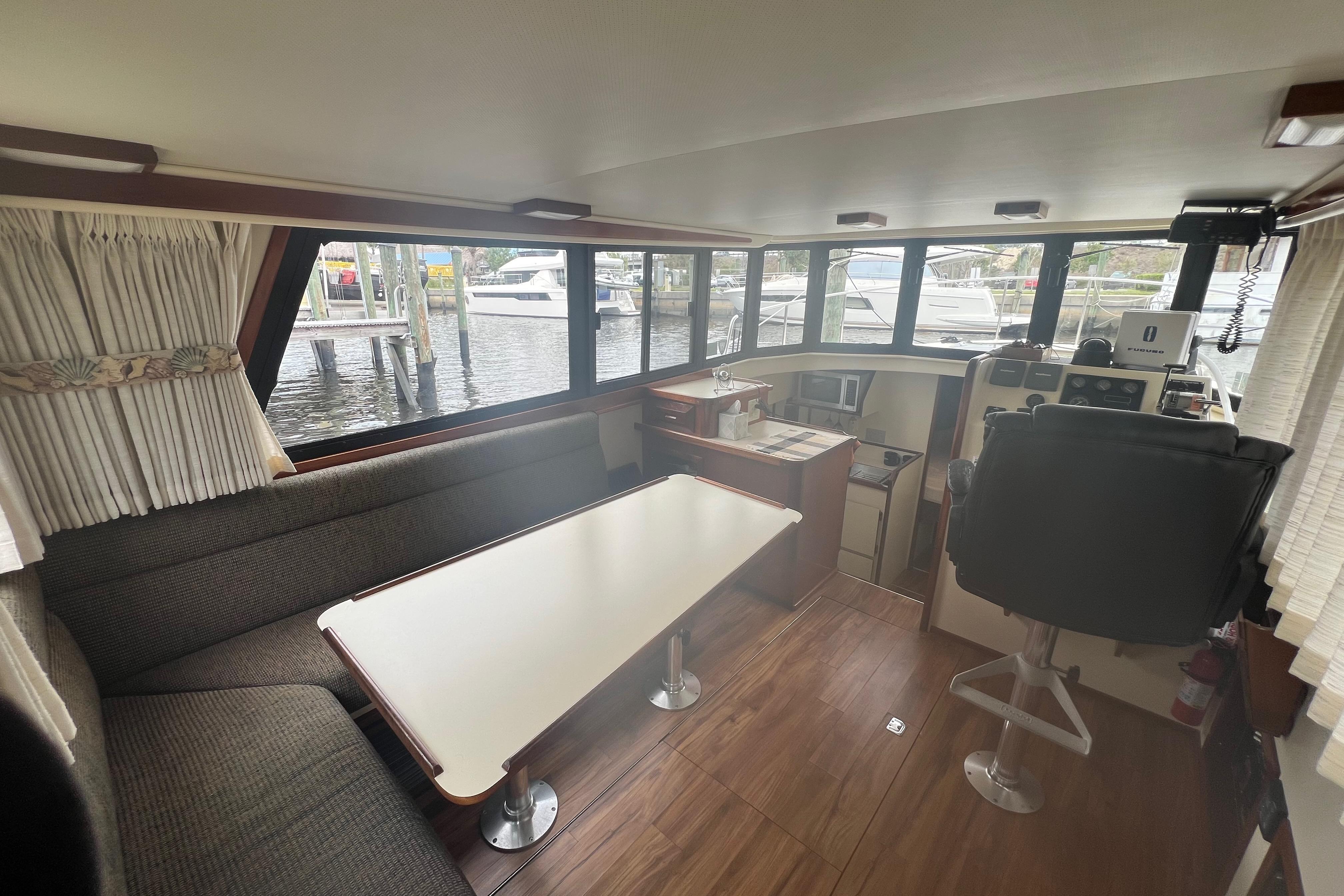 Interior of 2002 Camano Troll boat with seating, table, and helm station.