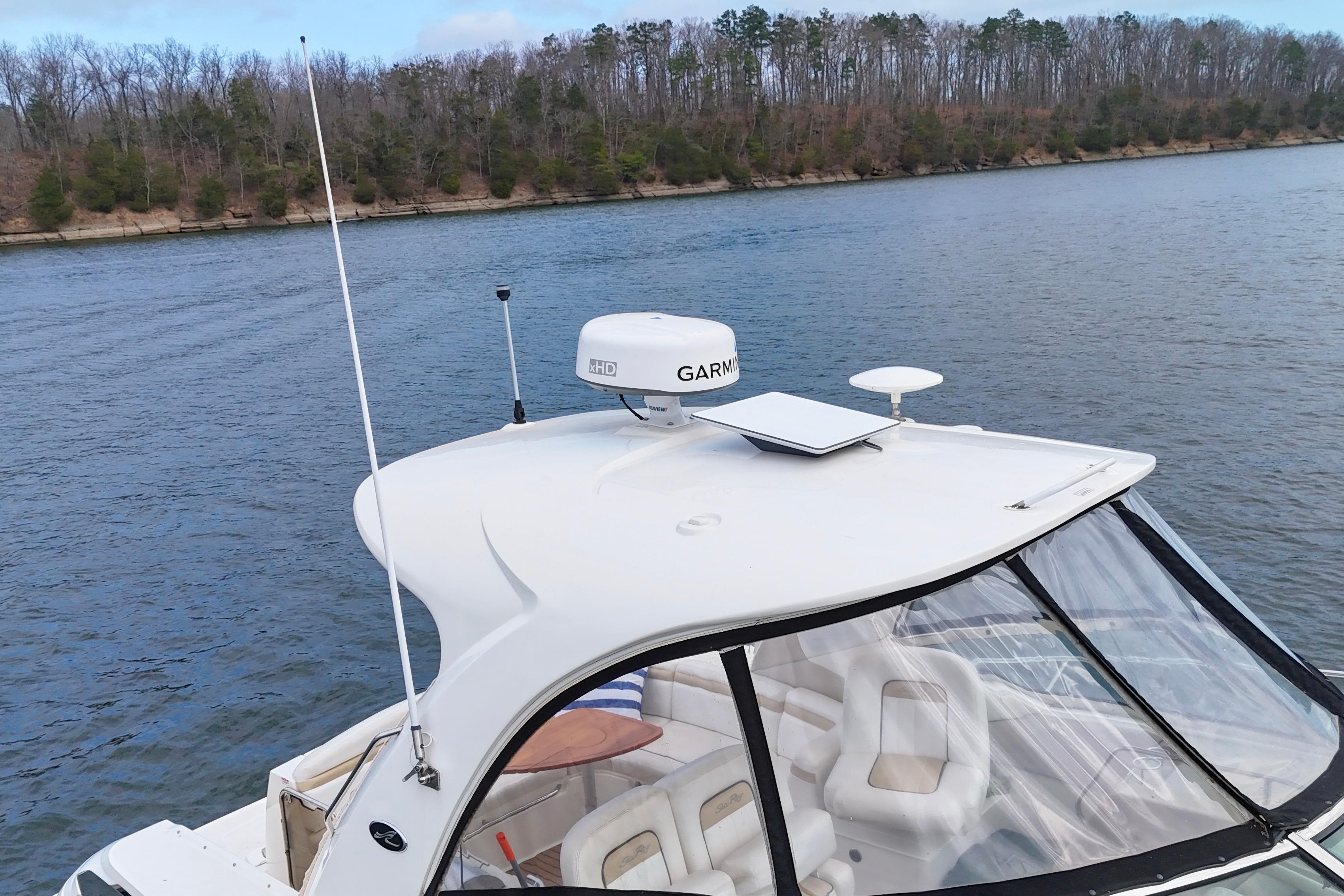 2009 Sea Ray Sundancer 350 boat on a calm river with wooded shoreline.