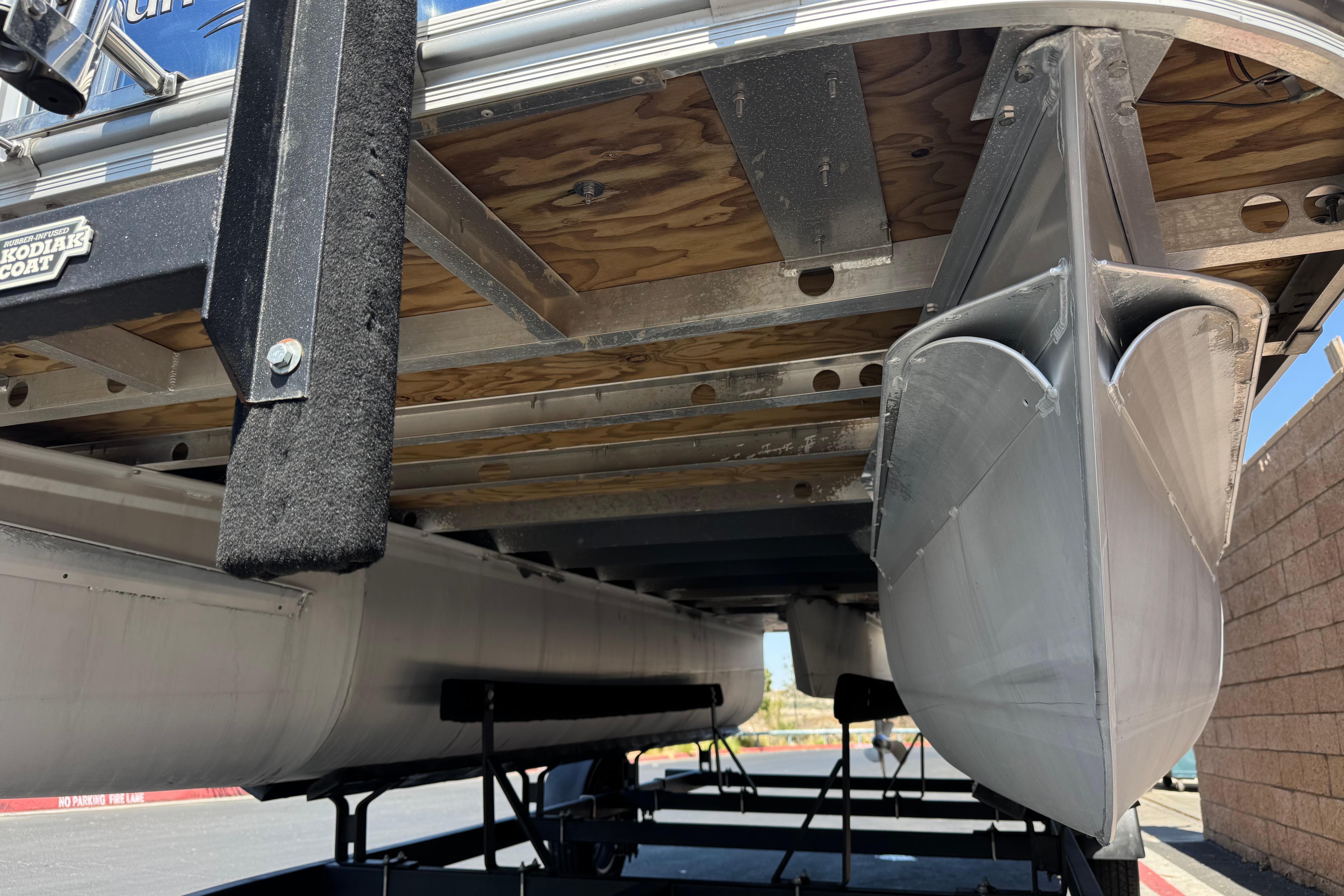Underneath view of a 2021 SunCatcher Select 20RCX pontoon boat on a trailer.