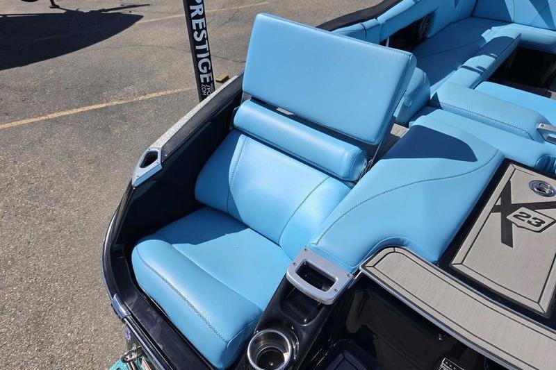 2017 MasterCraft X23 boat with blue seating and cup holders.